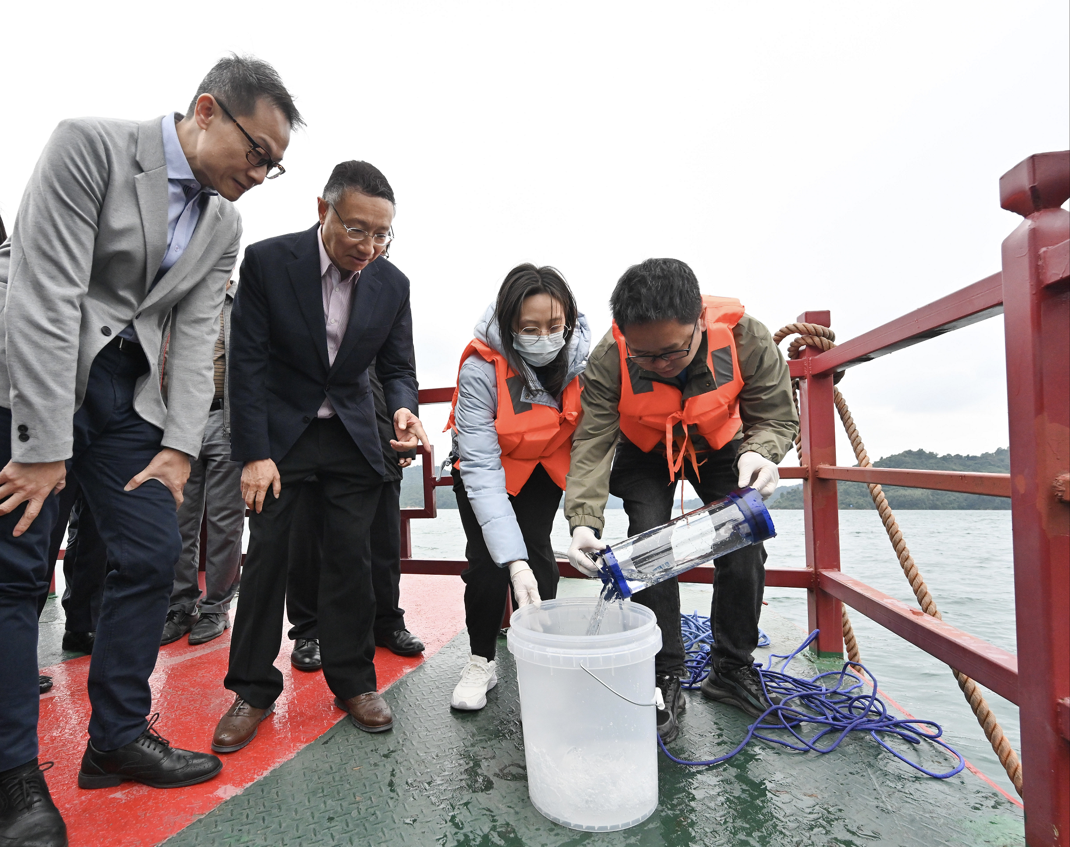 The Advisory Committee on Water Supplies (ACWS) delegation left for Guangdong Province yesterday (November 13) to visit the Dongjiang Water Supply System and returned to Hong Kong this afternoon (November 14). Photo shows the Chairman of the ACWS, Professor Joseph Kwan (second left), and the Director of Water Supplies, Mr Tony Yau (first left), taking a boat trip to visit the Xinfengjiang Reservoir and inspect the quality of water sample there yesterday.