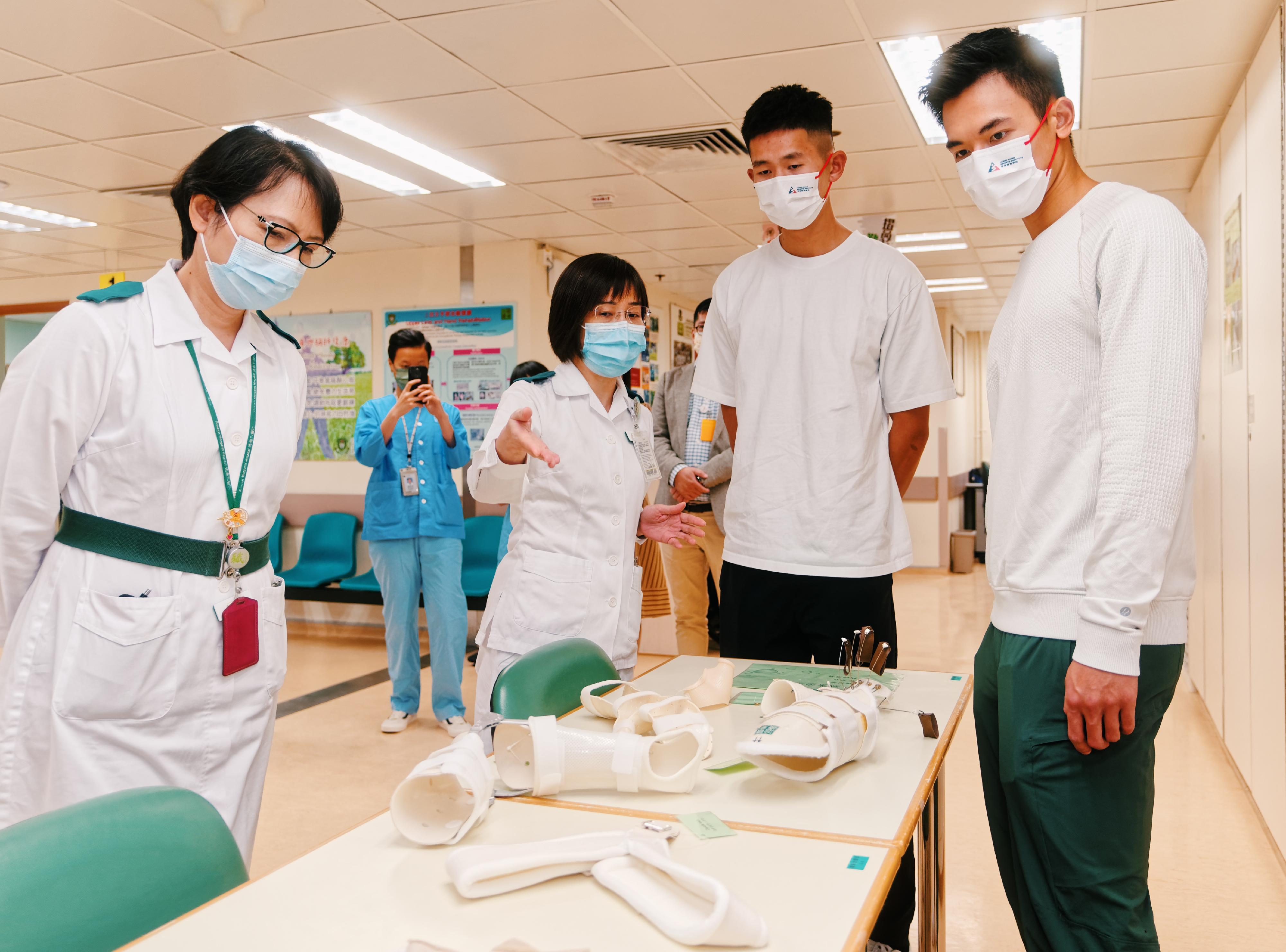 於杭州第19屆亞洲運動會奪得男子雙人單槳無舵艇金牌的林新棟（右一）及王瑋駿（右二）十一月十三日到訪瑪嘉烈醫院腦神經綜合復康中心，了解職業治療部提供的復康治療和輔助器具。