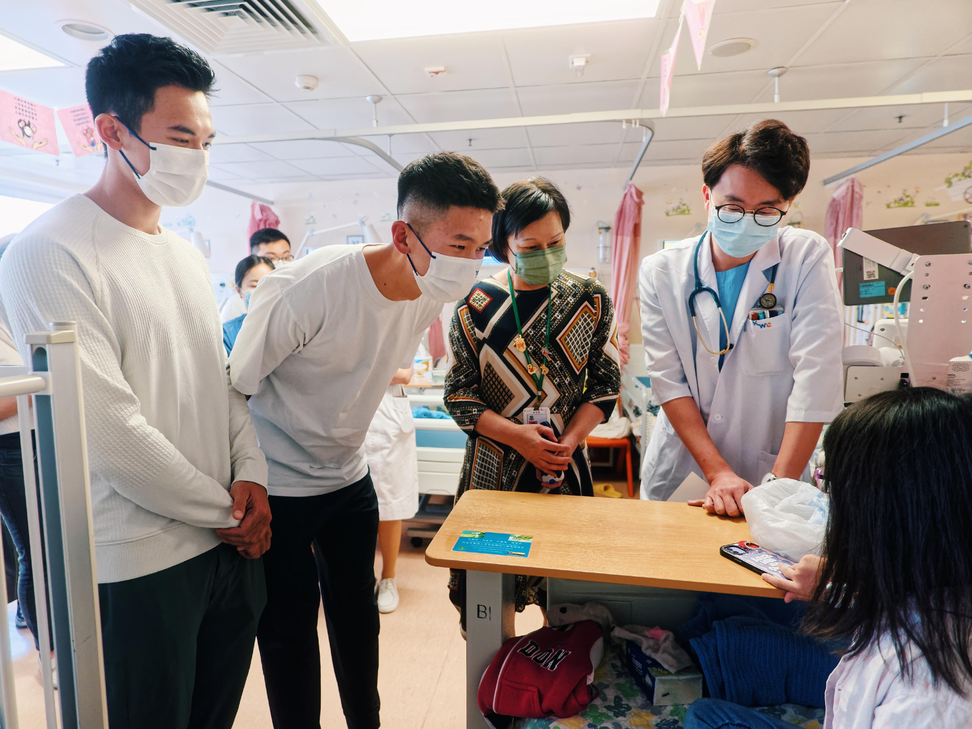 Lam San-tung (first left) and Wong Wai-chun (second left), who won the gold medal in Rowing Men's Coxless Pairs in the 19th Asian Games Hangzhou, visited Princess Margaret Hospital on November 13, where they interacted with paediatric patients and wished them a speedy recovery.