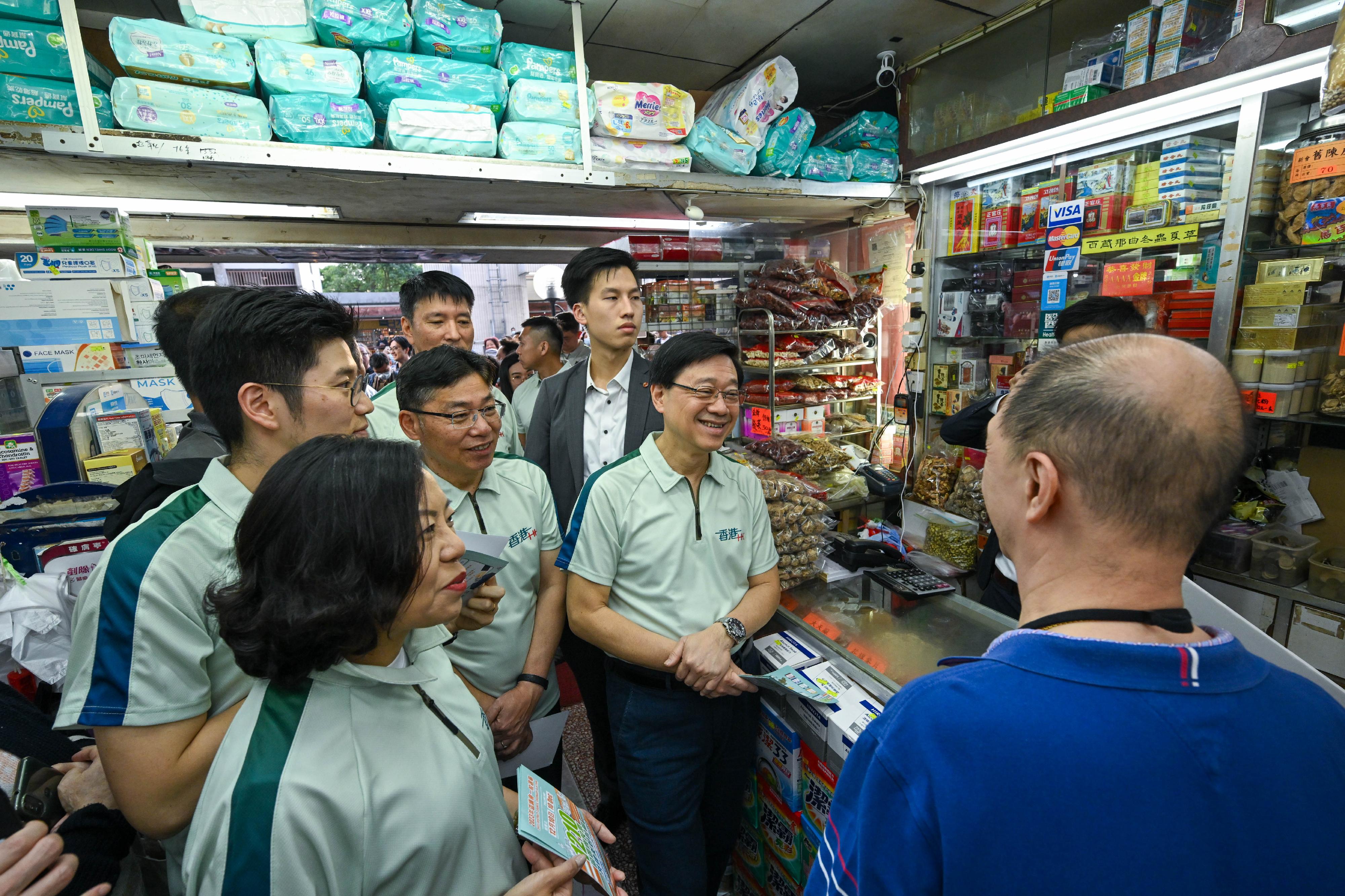 The Chief Executive, Mr John Lee, visited Shun Lee Estate in Kwun Tong today (November 15). Photo shows Mr Lee (front row, first right), accompanied by the Secretary for Transport and Logistics, Mr Lam Sai-hung (front row, second right) and the Secretary for Home and Youth Affairs, Miss Alice Mak (front row, third right), exchanging views with a merchant to learn about his views on measures to strengthen the economy and improve people's livelihood in the Policy Address.