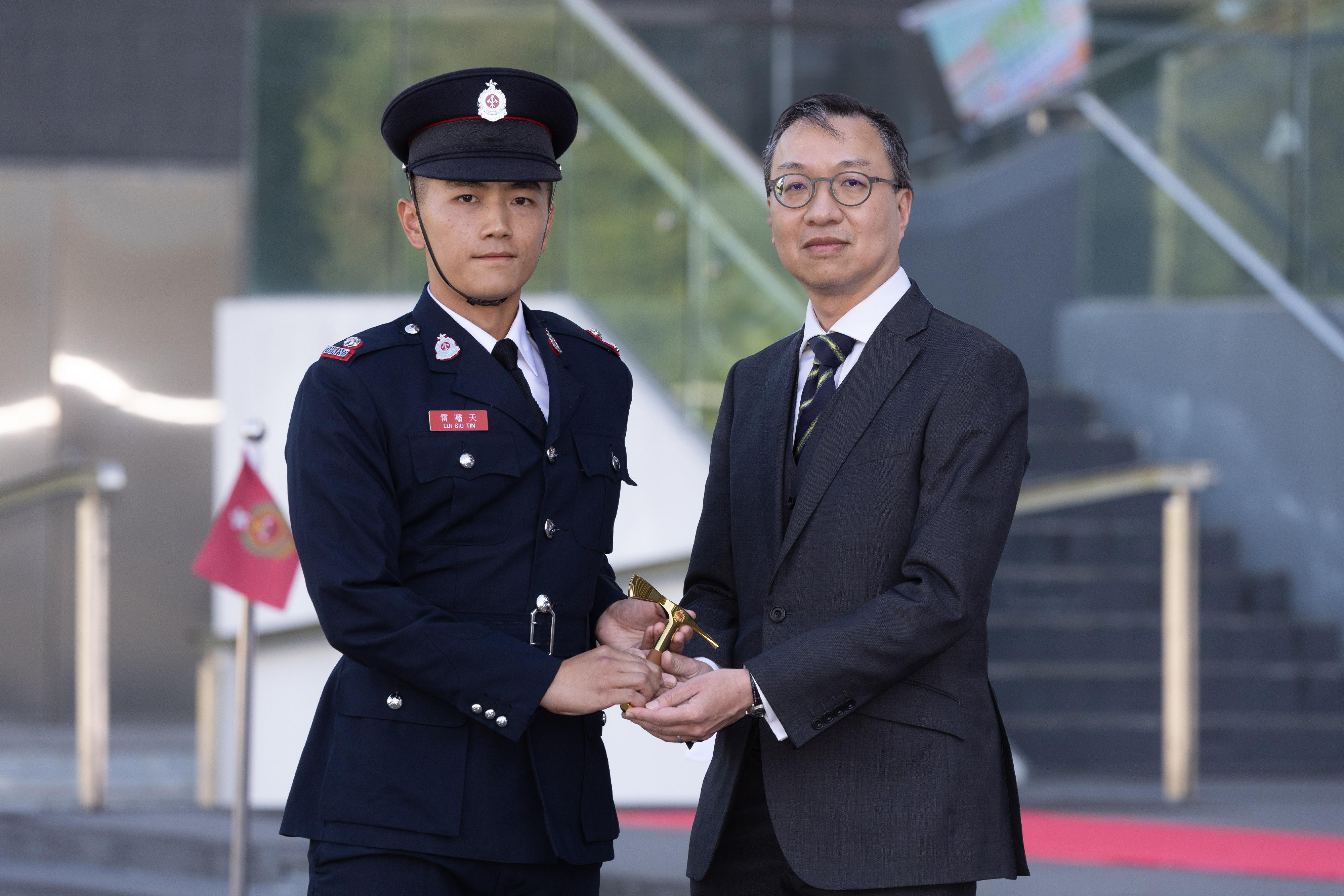 The Secretary for Justice, Mr Paul Lam, SC, reviewed the Fire Services passing-out parade at the Fire and Ambulance Services Academy today (November 17). Photo shows Mr Lam (right) presenting the Best Recruit Station Officer award to a graduate.
