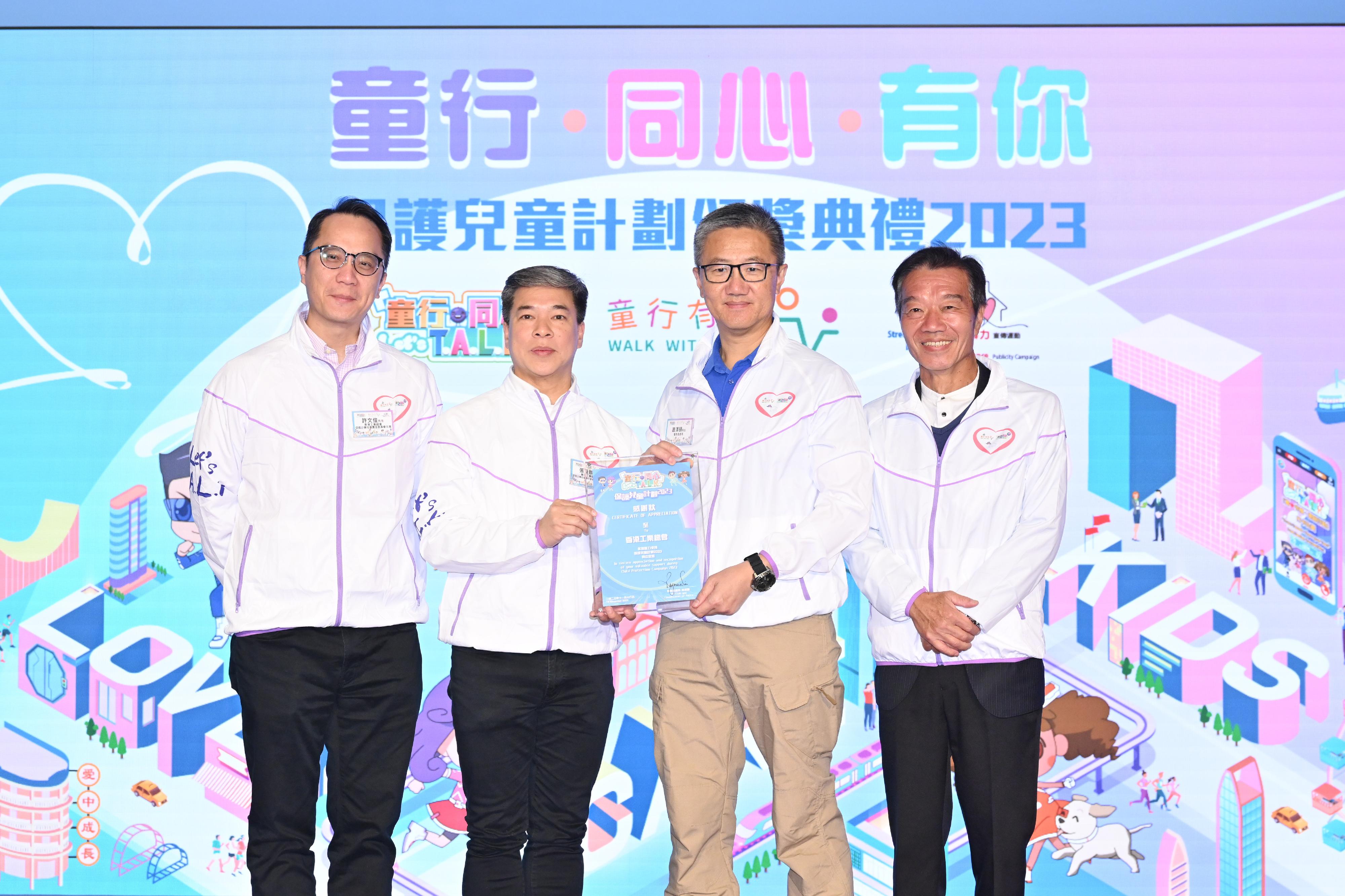 The Chief Secretary for Administration and Chairperson of the Commission on Children, Mr Chan Kwok-ki, today (November 18) officiated at the "Let's T.A.L.K. and Walk with Kids" Child Protection Campaign Award Presentation Ceremony 2023. Photo shows the Commissioner of Police, Mr Siu Chak-yee (second right), presenting a souvenir to representatives of a supporting organisation of the Child Protection Campaign.