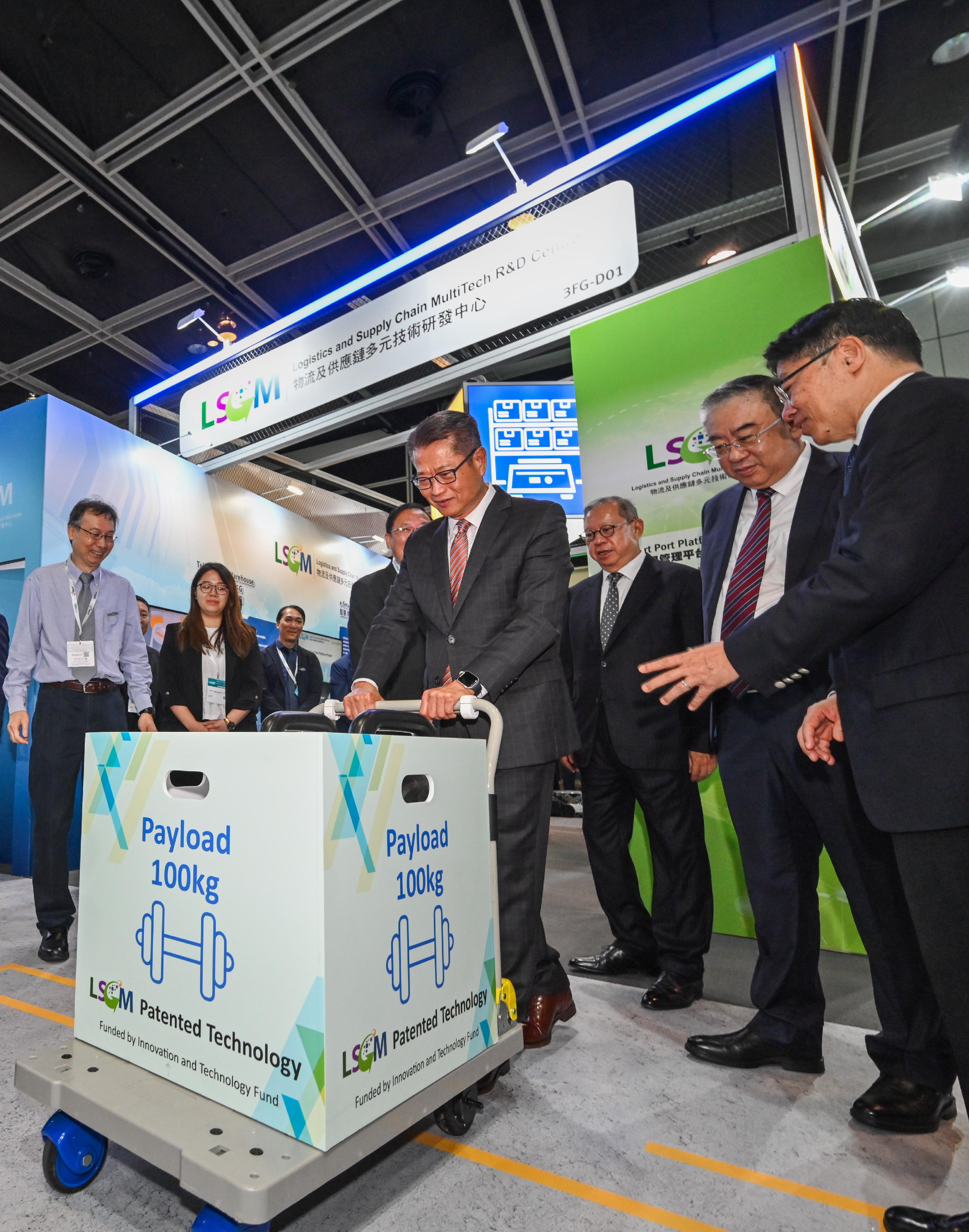The Financial Secretary, Mr Paul Chan, attended the Asian Logistics, Maritime and Aviation Conference 2023 today (November 21). Photo shows Mr Chan (fourth right) learning about an electronic power assist trolley system while touring the exhibition.