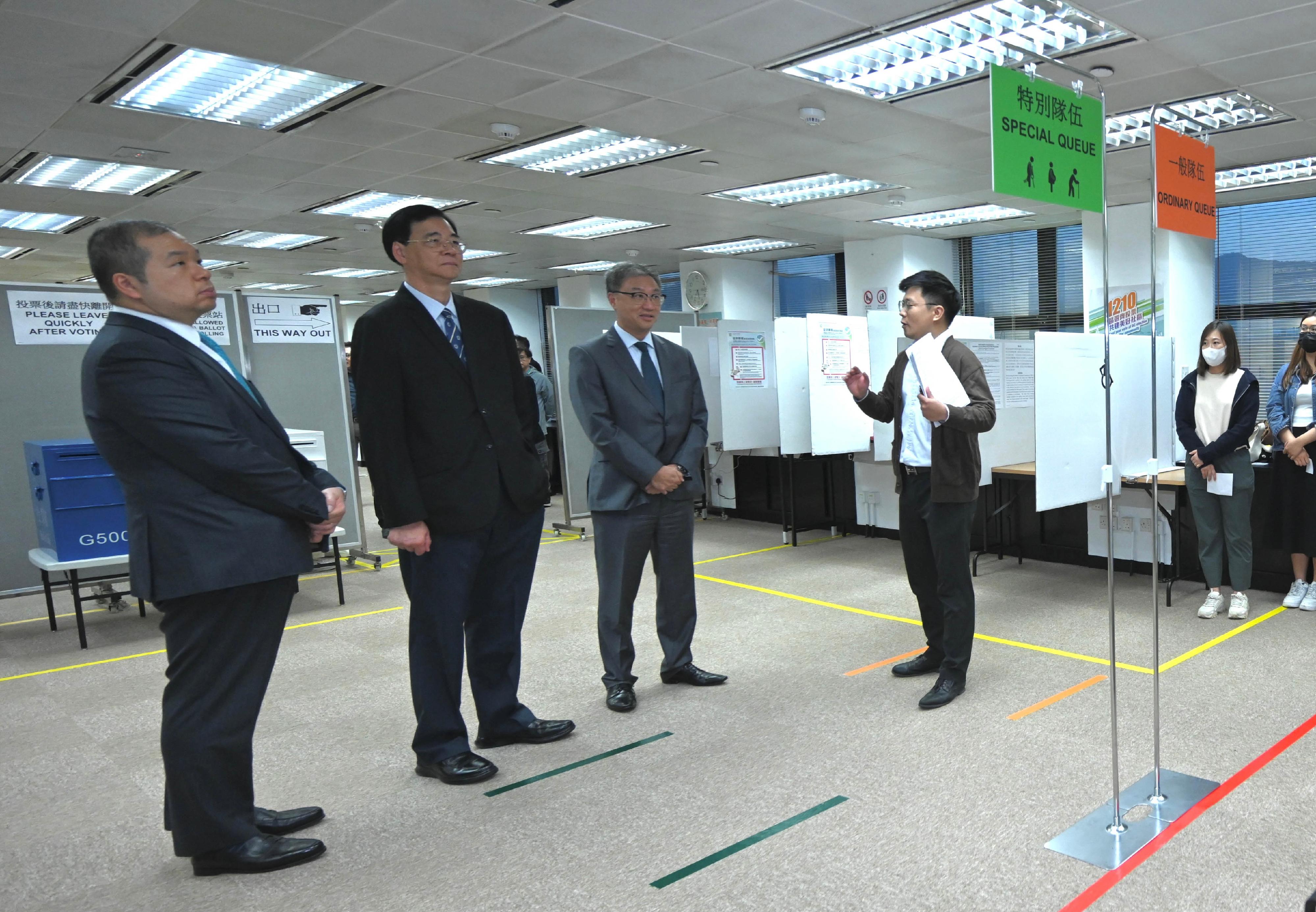 選舉管理委員會（選管會）主席陸啟康法官今日（十一月二十三日）視察選舉事務處的二○二三年區議會一般選舉的投票及點票安排示範。圖示陸啟康法官（左三）聽取選舉事務處工作人員簡介一般隊伍和特別隊伍的運作。旁為選管會委員石丹理教授（左二）和文本立資深大律師（左一）。