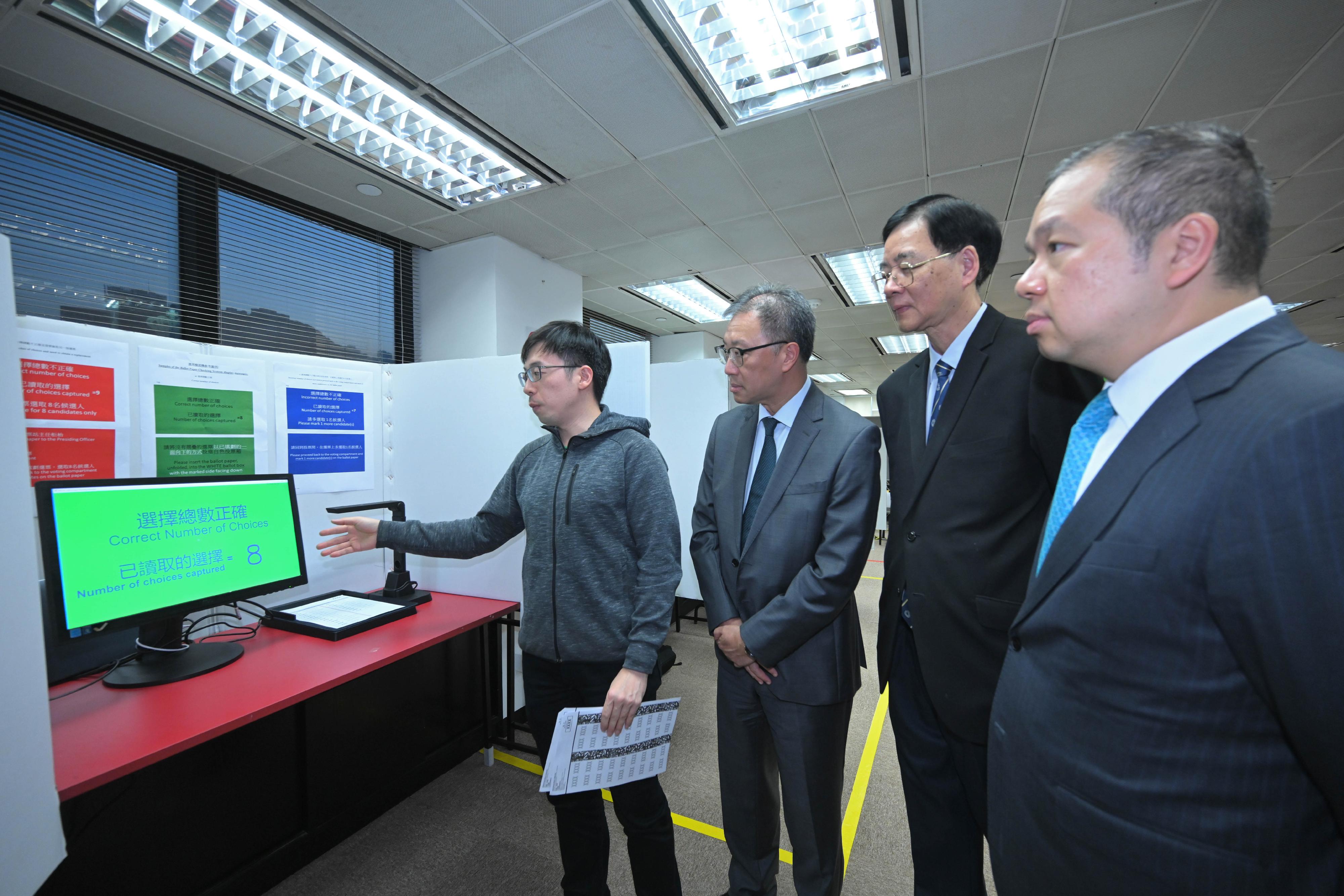 The Chairman of the Electoral Affairs Commission (EAC), Mr Justice David Lok, today (November 23) inspected the demonstration of polling and counting arrangements by the Registration and Electoral Office (REO) for the 2023 District Council Ordinary Election. Photo shows Mr Justice Lok (third right) being briefed by staff of the REO on the ballot paper checking system installed at District Committees constituency polling stations. Also present were the EAC members Professor Daniel Shek (second right) and Mr Bernard Man, SC (first right).