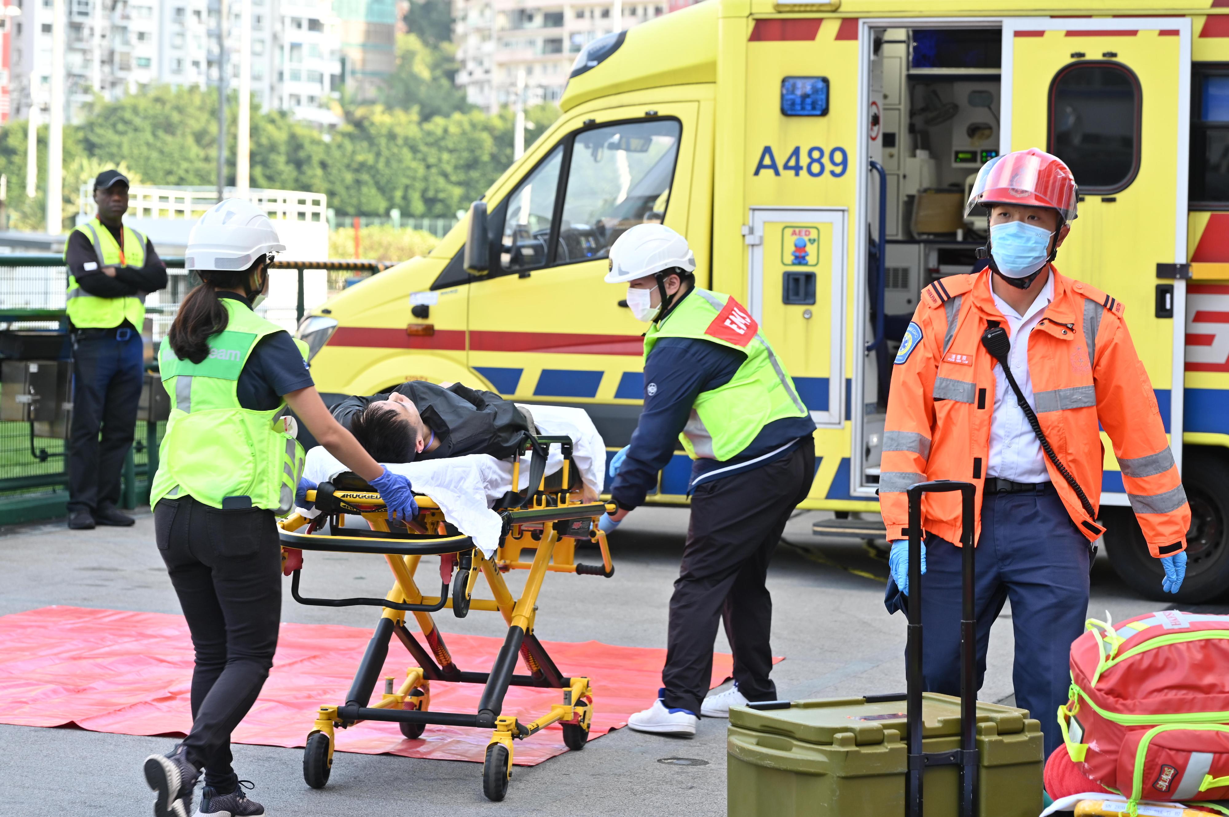 警务处港岛总区今日（十一月二十三日）下午联同消防处、医院管理局、香港赛马会、圣约翰救伤队及香港危难应变医学会在跑马地马场举行代号「碎针」的跨部门重大事故演习。图示人员将伤者送院。