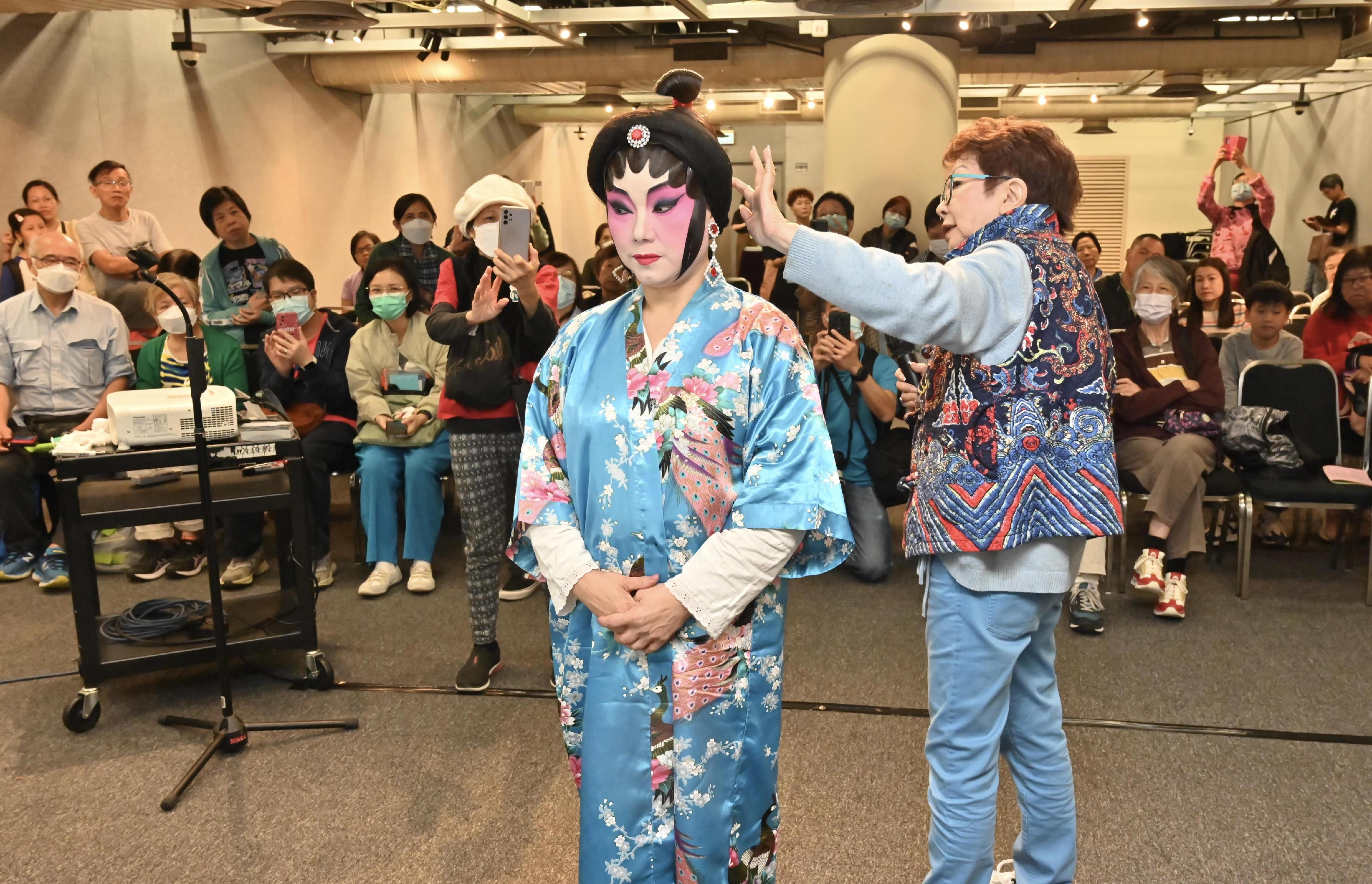 粵劇演員向觀眾示範戲服穿戴。