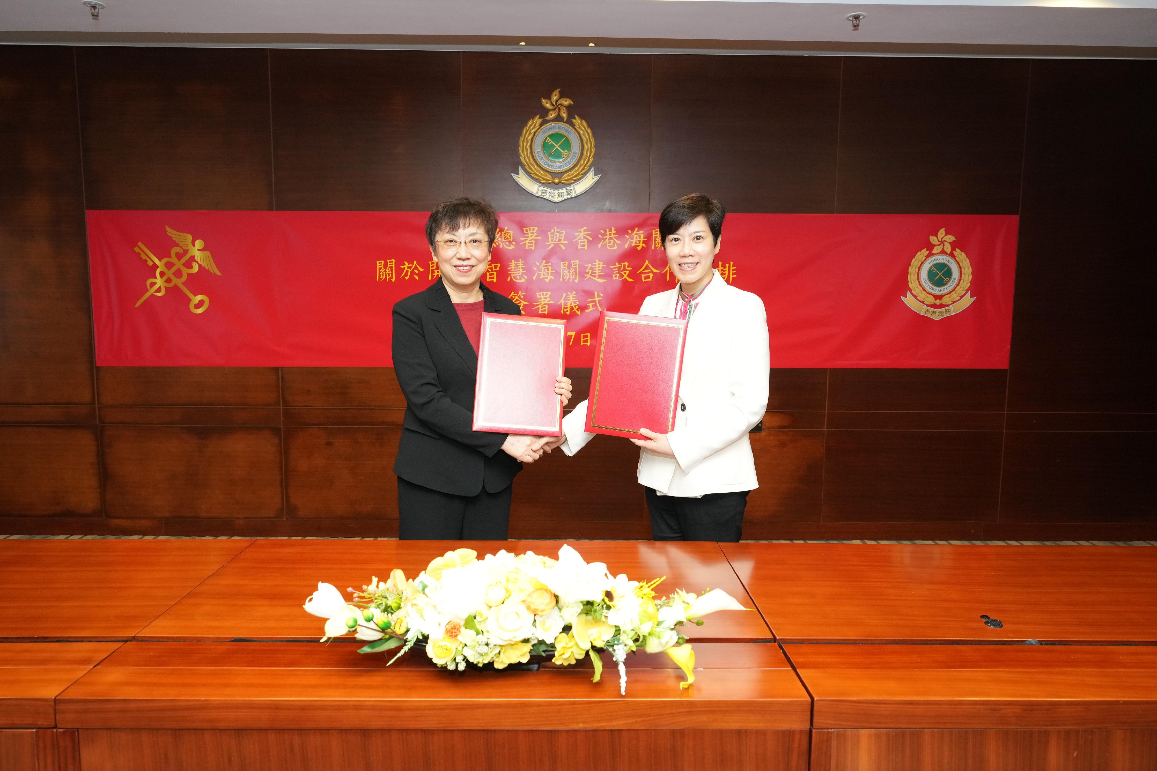 The Commissioner of Customs and Excise, Ms Louise Ho (right), and Vice Minister of General Administration of Customs of the People's Republic of China (GACC) Ms Lv Weihong (left) sign the Co-operative Arrangement on Smart Customs Development between the GACC and Hong Kong Customs at the Customs Headquarters Building today (November 27).