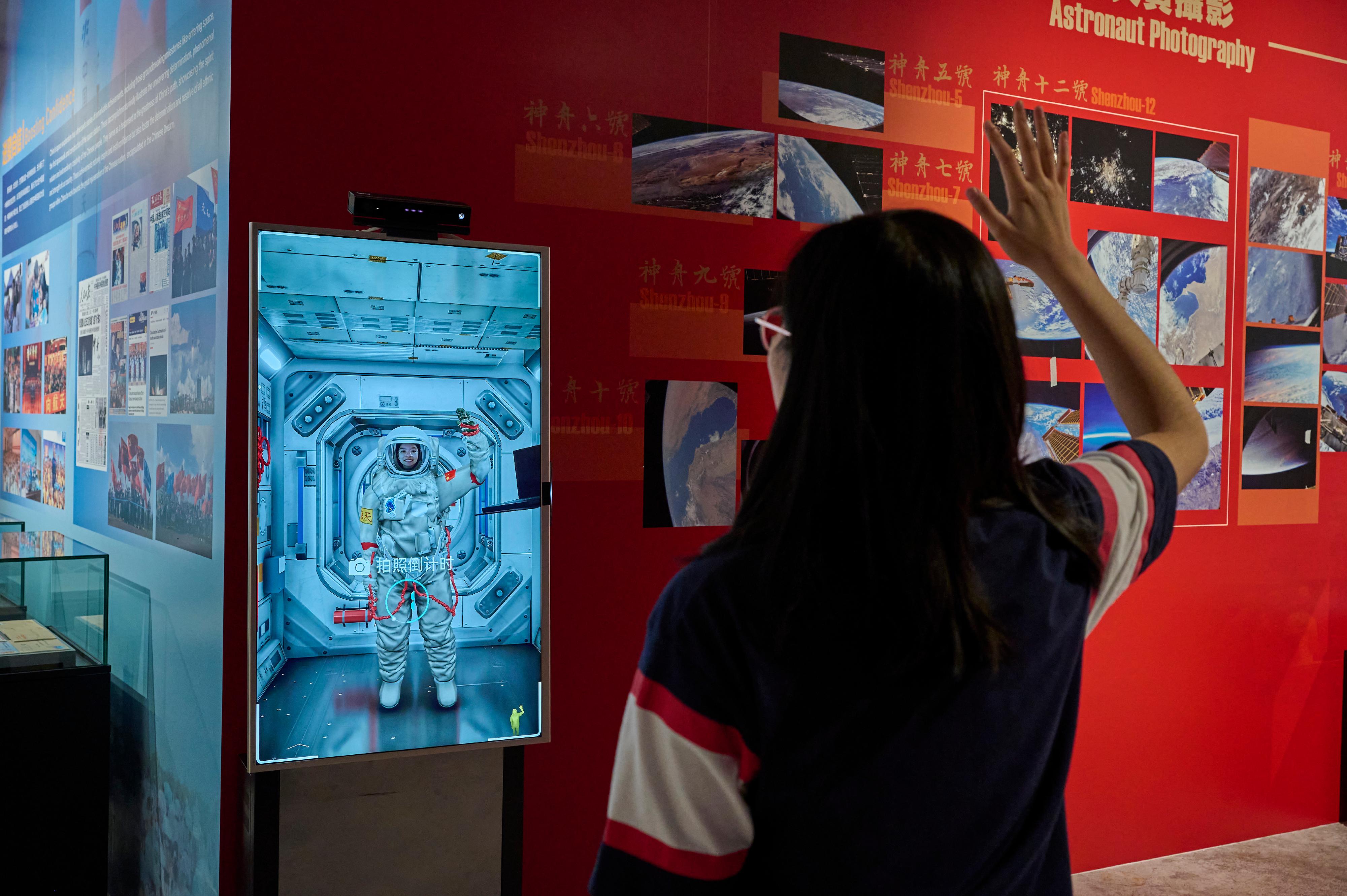 觀眾在「太空照相館」穿上虛擬航天服，在空間站艙內和艙外拍攝相片留念。