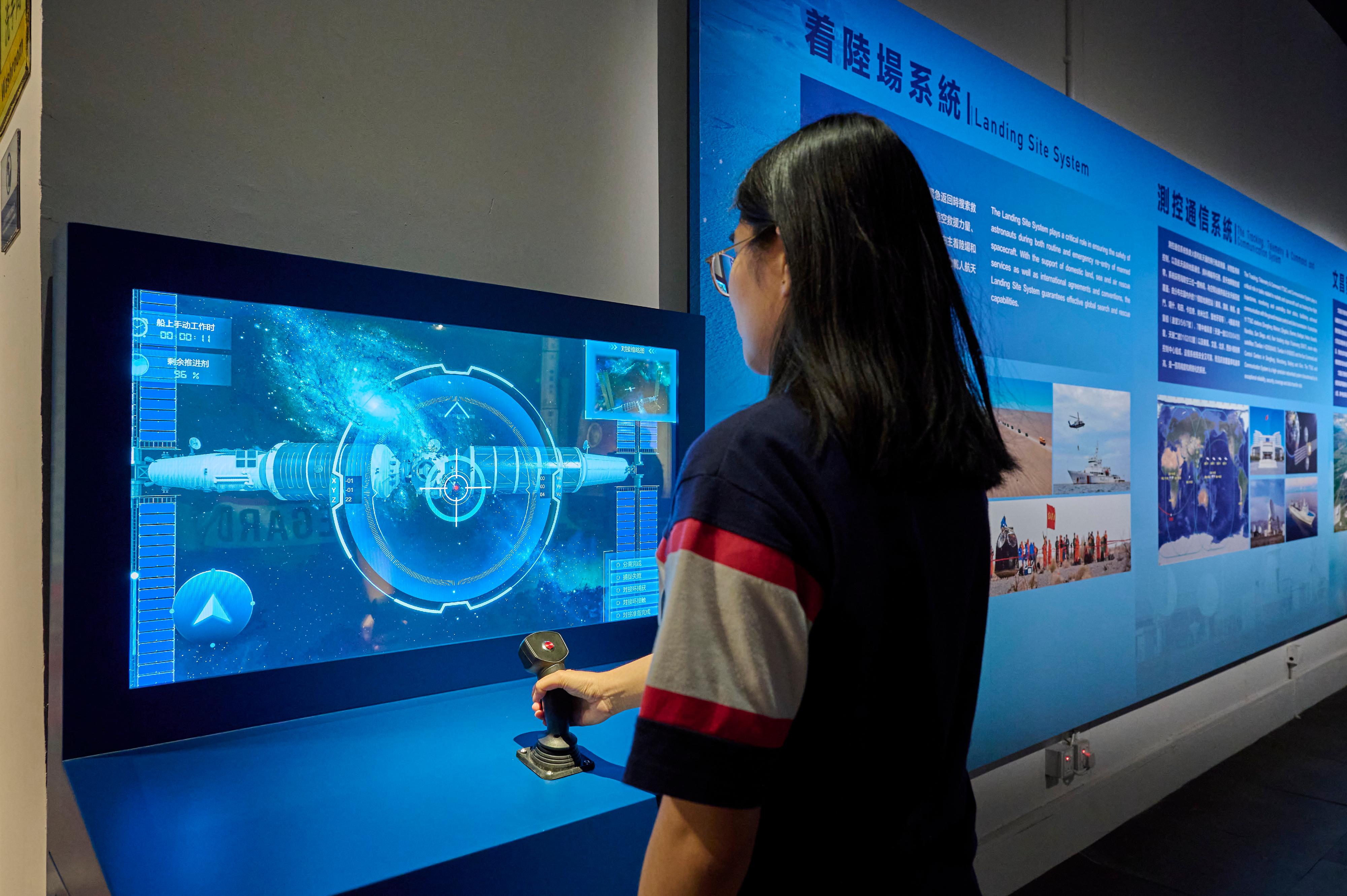 中国载人航天工程展明日（十二月一日）起至明年二月十八日在香港科学馆和香港历史博物馆举行。图示互动展品「空间站交会对接」，观众可模拟航天员控制神舟载人飞船与空间站进行交会对接。
