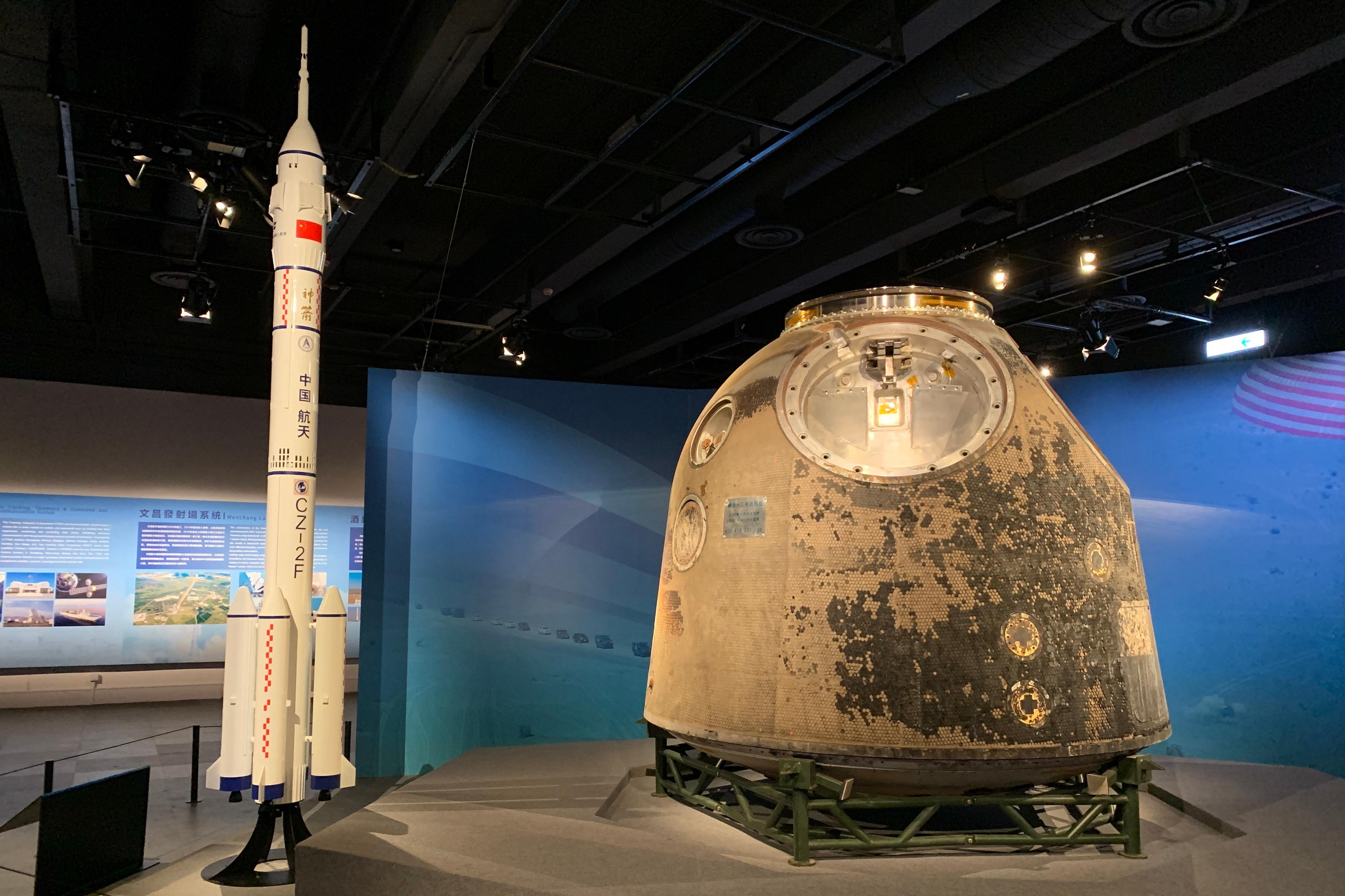 中国载人航天工程展明日（十二月一日）起至明年二月十八日在香港科学馆和香港历史博物馆举行。图示神舟十三号载人飞船返回舱及长征二号F运载火箭一比十五的模型。