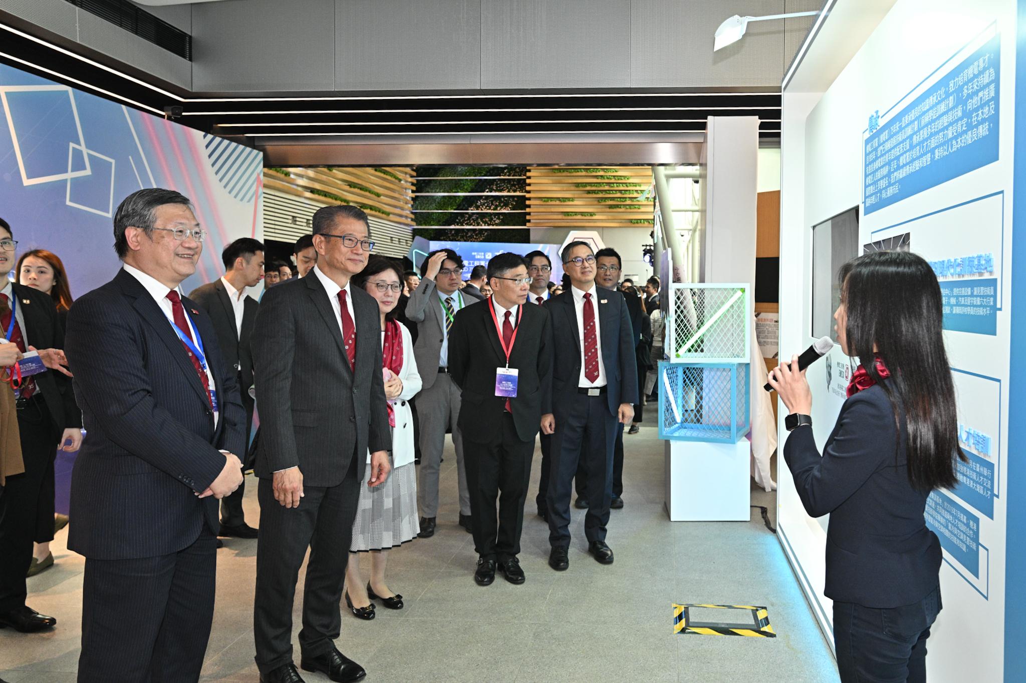 財政司司長陳茂波今日（十一月三十日）出席機電工程署七十五周年典禮。圖示陳茂波（左二）聽取職員介紹該署的最新科技應用。

