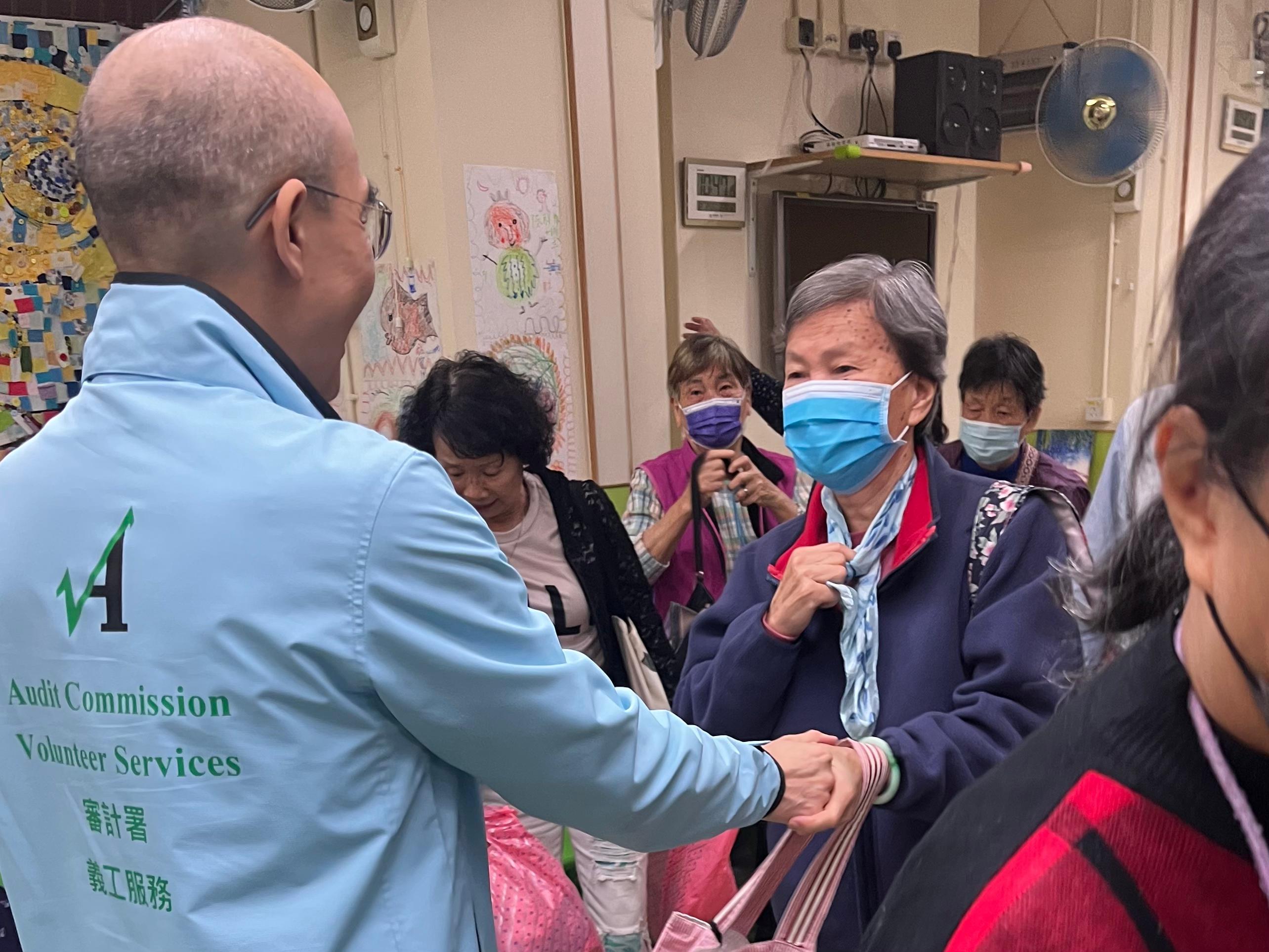 Around 30 volunteers from the Audit Commission takes part in volunteer visit to elderly centre and District Council election promotion activity today (December 2). Photo shows a volunteer from the Audit Commission chatting with an elderly.    