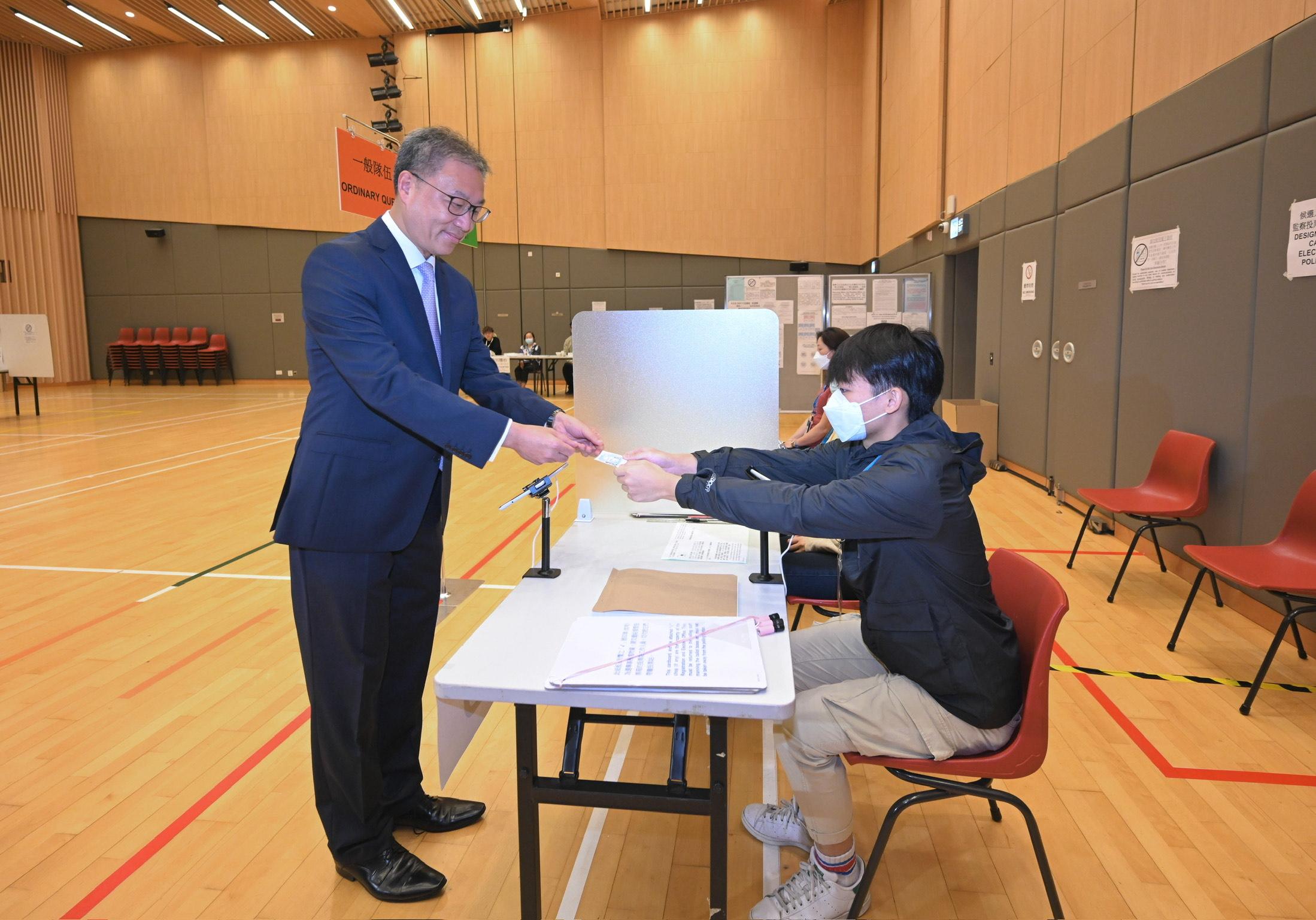 The Chairman of the Electoral Affairs Commission, Mr Justice David Lok (left), demonstrated the proper polling procedures of the District Council Ordinary Election during his visit to a mock polling station at the North Point Community Hall today (December 5). Photo shows Mr Justice Lok demonstrating the collection of a ballot paper using the Electronic Poll Register system.