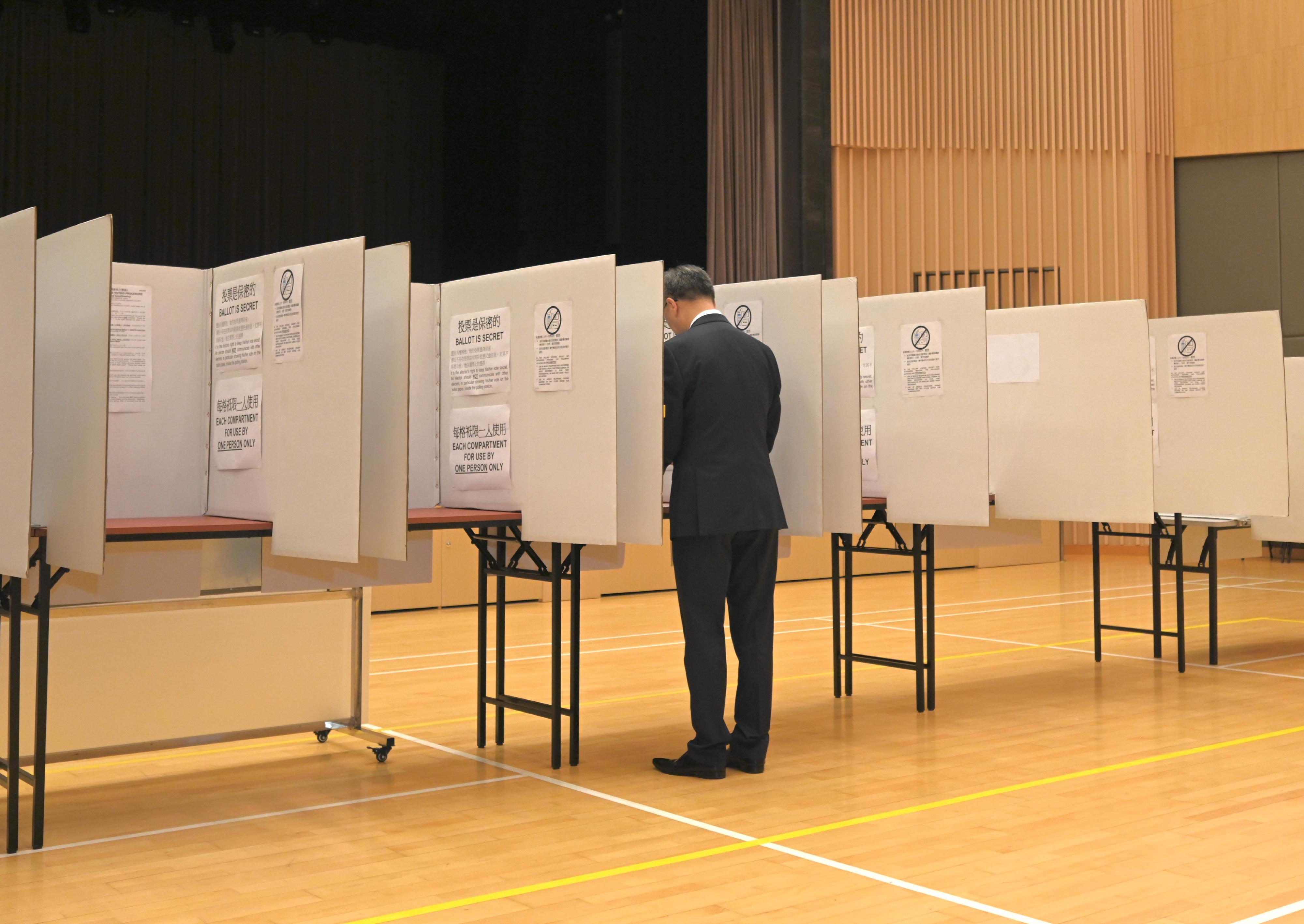 The Chairman of the Electoral Affairs Commission, Mr Justice David Lok, demonstrated the proper polling procedures of the District Council Ordinary Election during his visit to a mock polling station at the North Point Community Hall today (December 5). Photo shows Mr Justice Lok demonstrating the marking of a ballot paper inside a voting compartment.