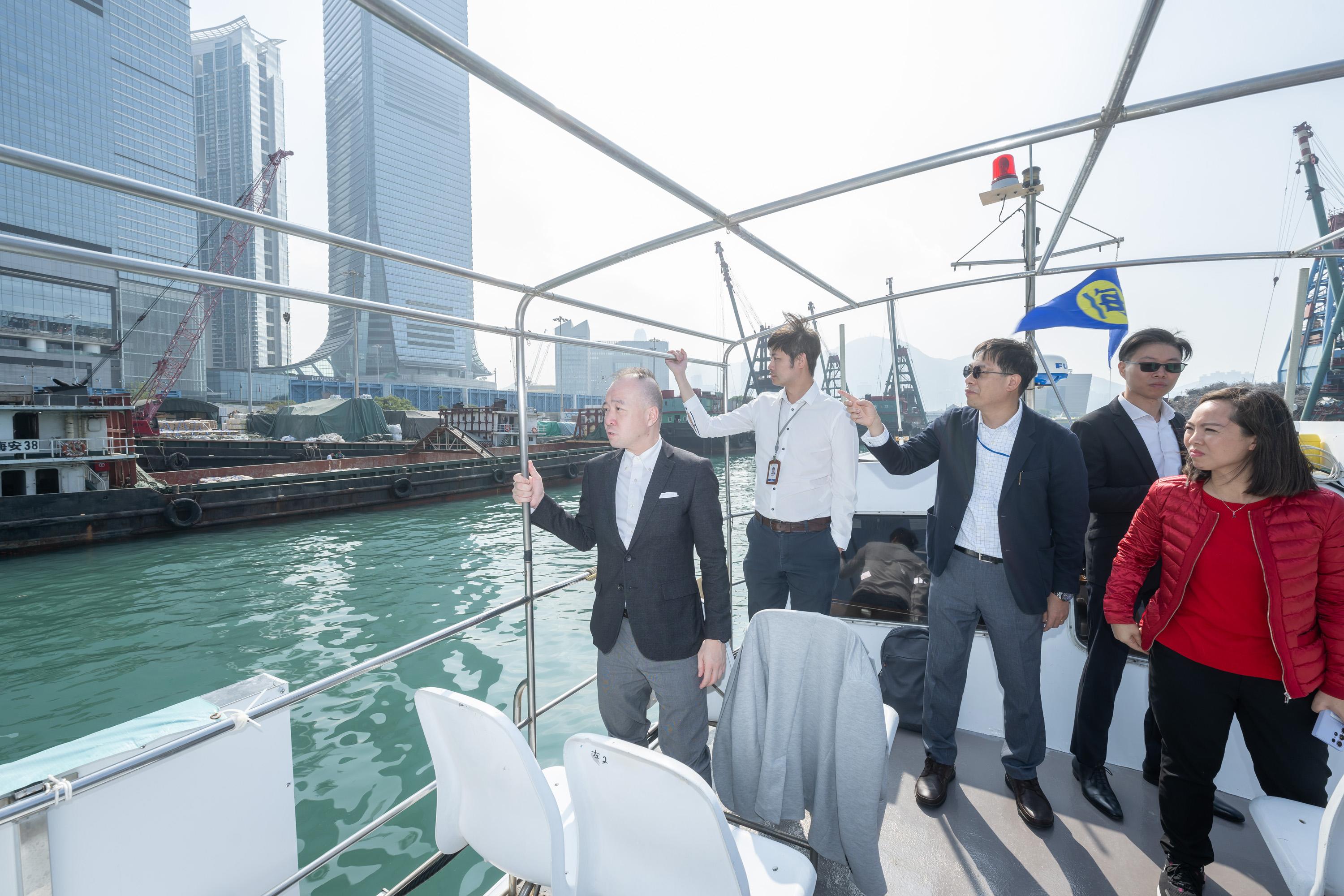 The Legislative Council (LegCo) Subcommittee to Study Matters Relating to Typhoon Shelters and Sheltered Anchorages conducts a site visit to the typhoon shelters at Aberdeen, Kwun Tong and Yau Ma Tei today (December 5). Photo shows LegCo Members receiving a briefing from representatives of the Marine Department on the management of the New Yau Ma Tei Typhoon Shelter on a Government launch.