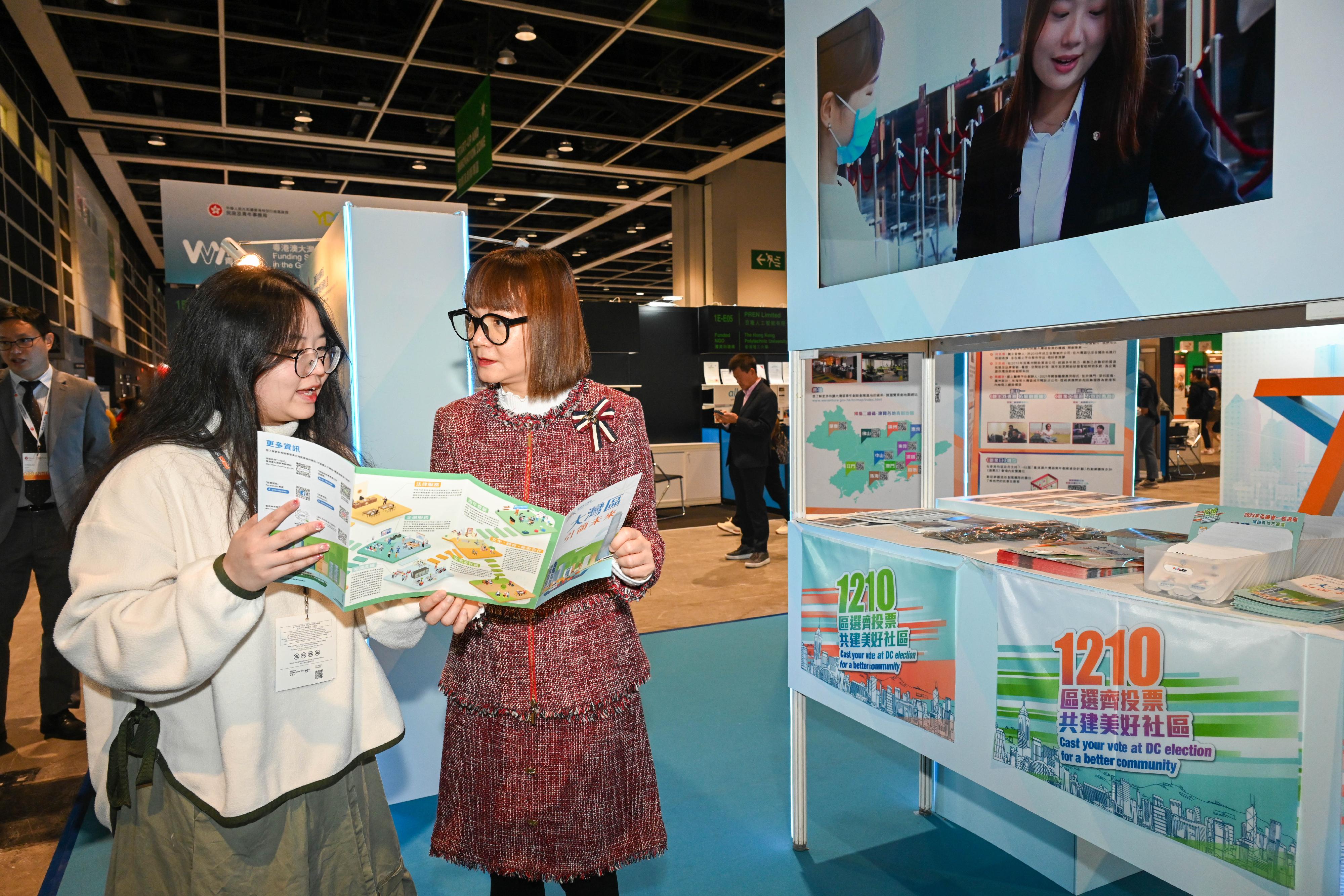 The Commissioner for the Development of the Guangdong-Hong Kong-Macao Greater Bay Area, Ms Maisie Chan (right), visits the Guangdong-Hong Kong-Macao Greater Bay Area Development Office's exhibition booth at the Entrepreneur Day exhibition today (December 7).