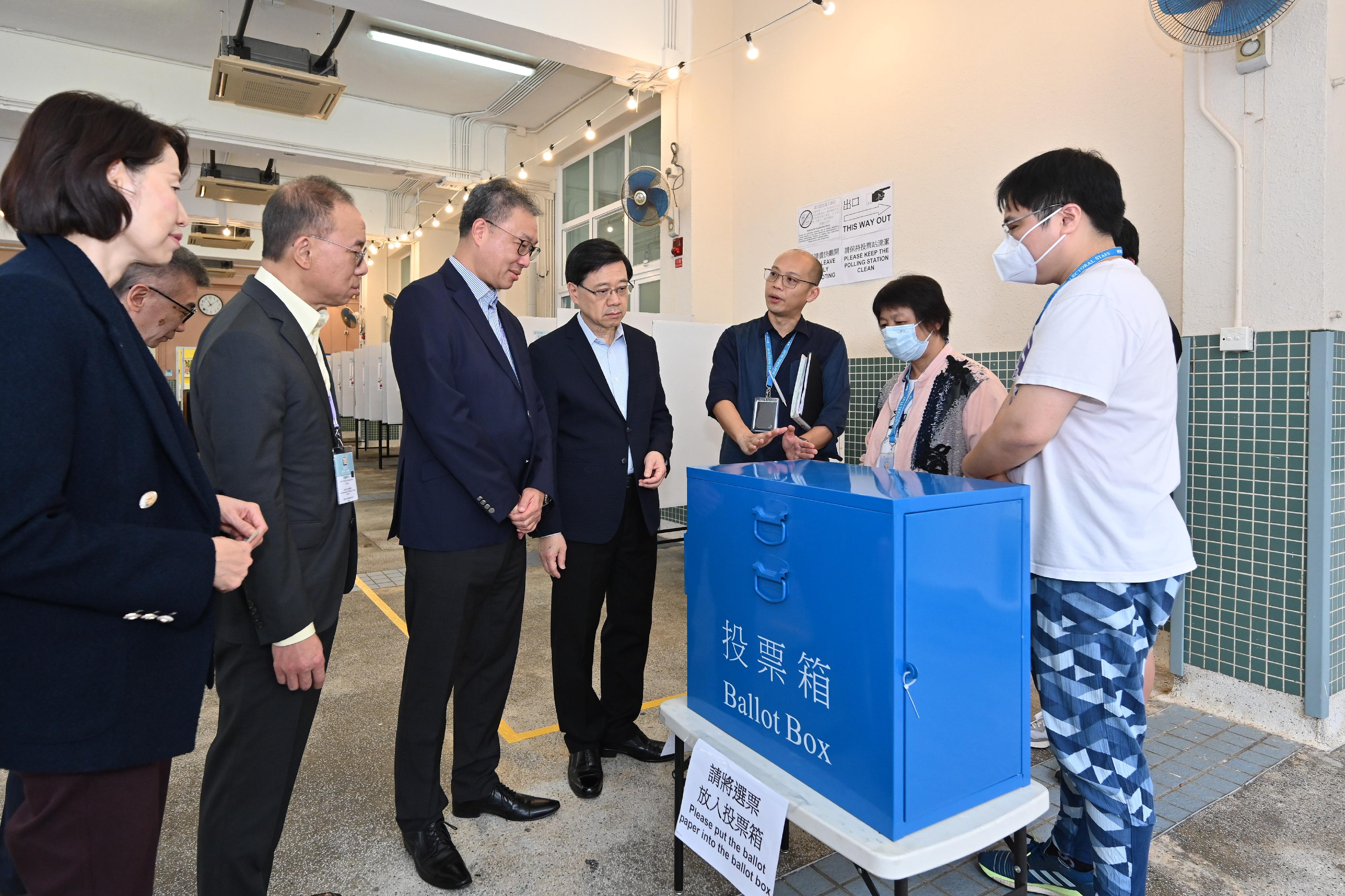 选举管理委员会主席陆启康法官（左三）今日（十二月九日）上午与政制及内地事务局局长曾国卫（左二），陪同行政长官李家超（左四）巡视位于岭南中学的二○二三年区议会一般选举区议会地方选区投票站。旁为行政长官办公室主任叶文娟（左一）。