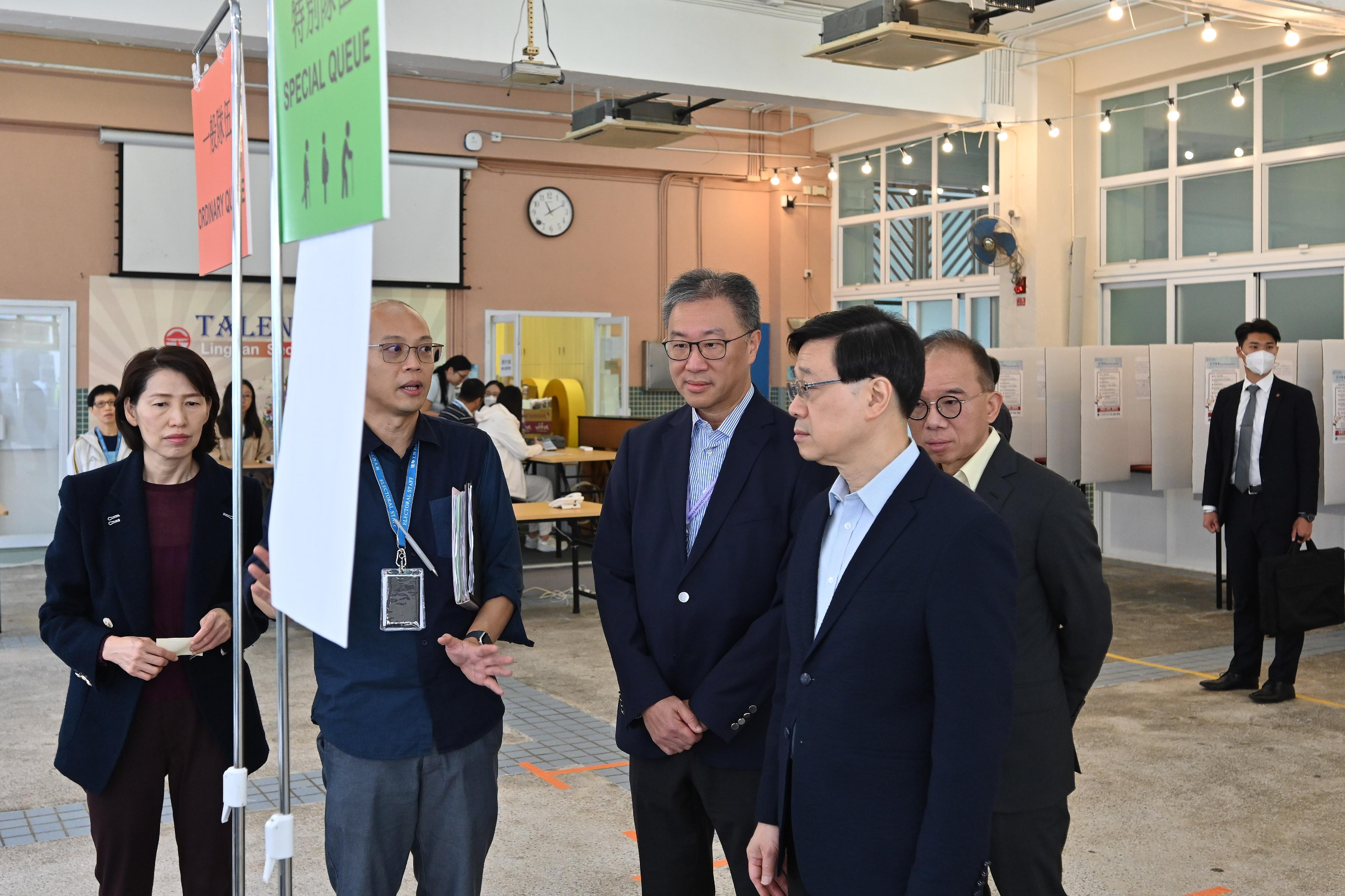 The Chairman of the Electoral Affairs Commission, Mr Justice David Lok (centre), and the Secretary for Constitutional and Mainland Affairs, Mr Erick Tsang Kwok-wai (first right), accompanied the Chief Executive, Mr John Lee (second right), to inspect the District Council geographical constituency polling station of the 2023 District Council Ordinary Election at Lingnan Secondary School this morning (December 9). Also present was the Director of the Chief Executive's Office, Ms Carol Yip (first left).