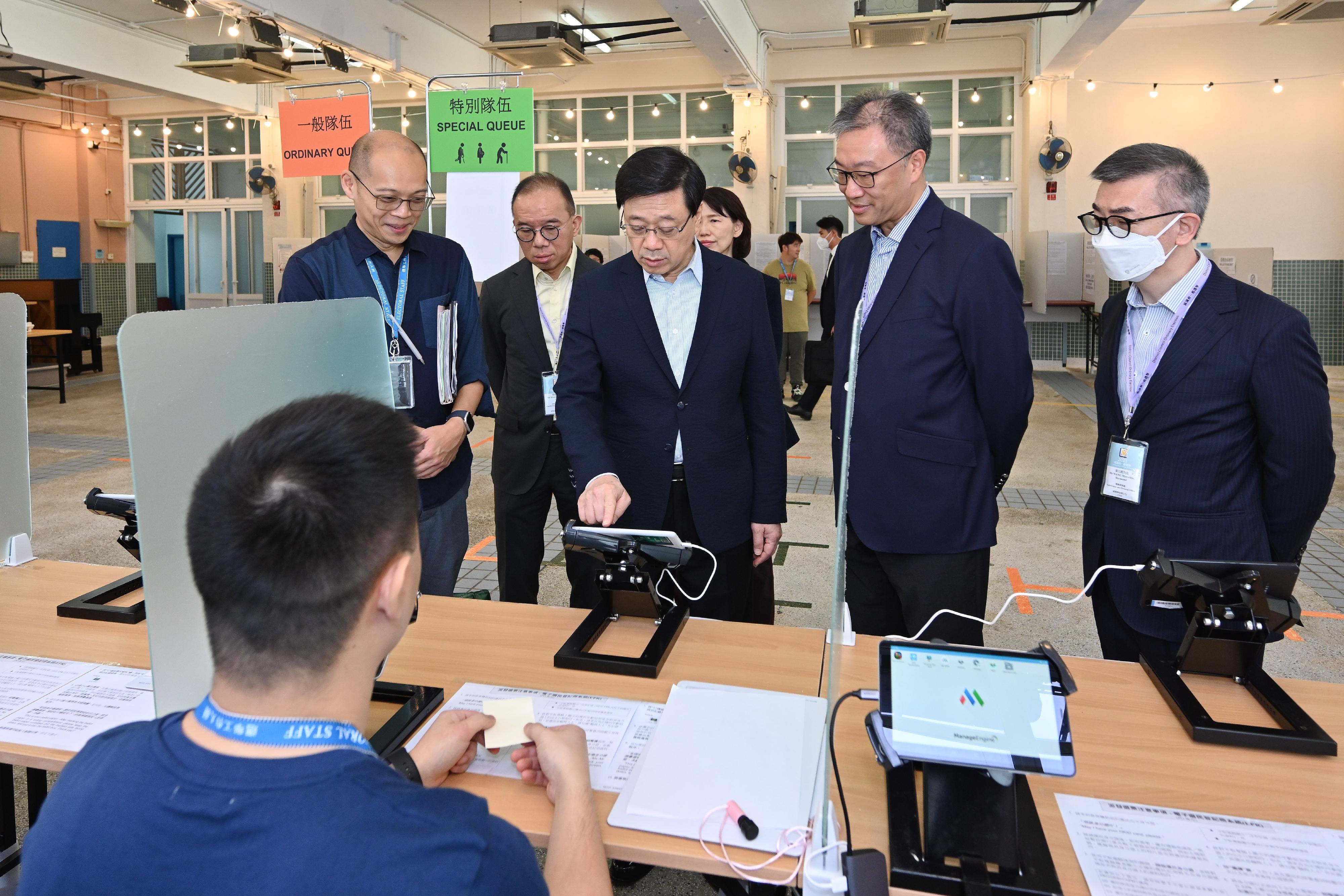 The Chairman of the Electoral Affairs Commission, Mr Justice David Lok (front row, centre), and the Secretary for Constitutional and Mainland Affairs, Mr Erick Tsang Kwok-wai (back row, centre), accompanied the Chief Executive, Mr John Lee (front row, left), to inspect the District Council geographical constituency polling station of the 2023 District Council Ordinary Election at Lingnan Secondary School this morning (December 9). Also present was the Chief Electoral Officer of the Registration and Electoral Office, Mr Raymond Wang (front row, right).