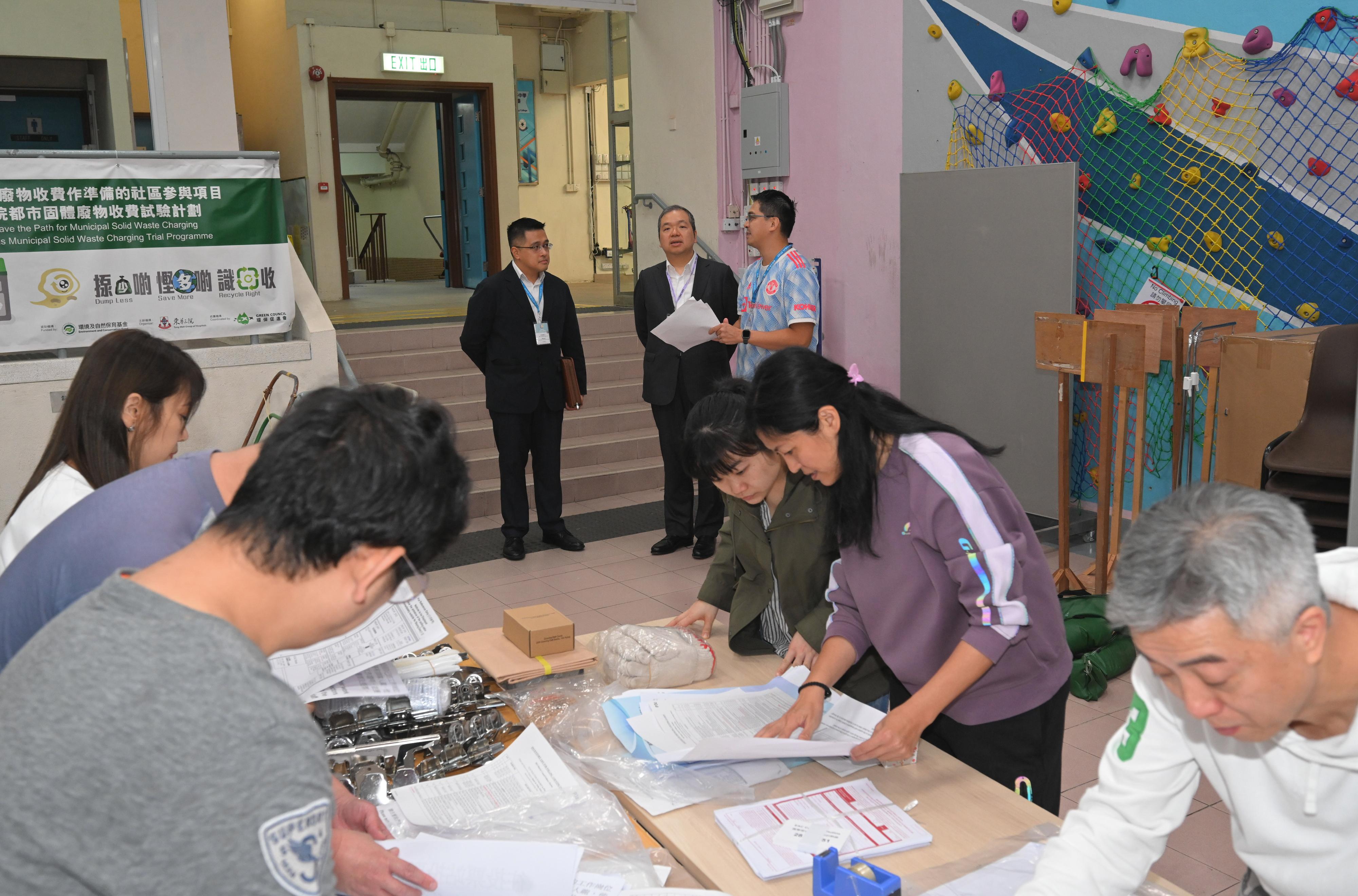 The Electoral Affairs Commission member Mr Bernard Man, SC (centre), visits a District Council geographical constituency polling station of the 2023 District Council Ordinary Election at the TWGHs Mrs Fung Wong Fung Ting College this morning (December 9) to inspect the preparatory work.