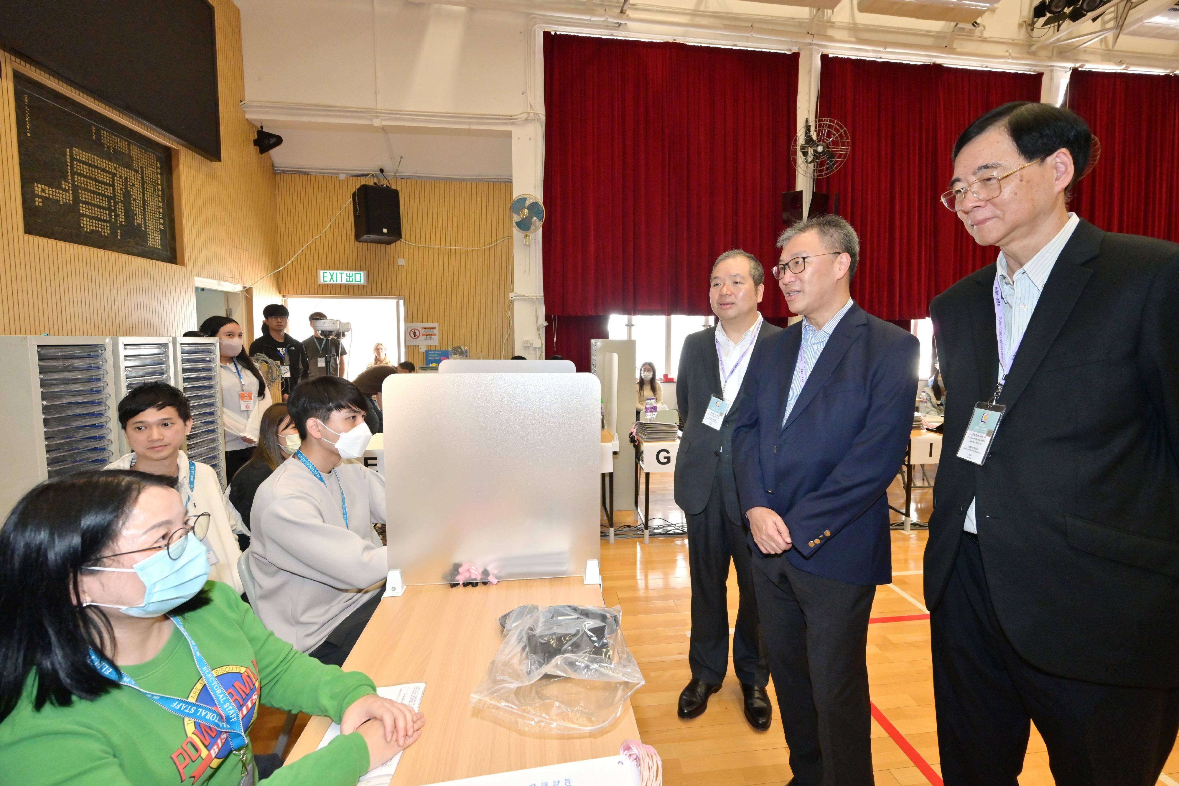 The Chairman of the Electoral Affairs Commission (EAC), Mr Justice David Lok (second right); the EAC members Professor Daniel Shek (first right) and Mr Bernard Man, SC (third right), visit a near boundary polling station of the 2023 District Council Ordinary Election this afternoon (December 9) to inspect the preparatory work of the electoral staff.