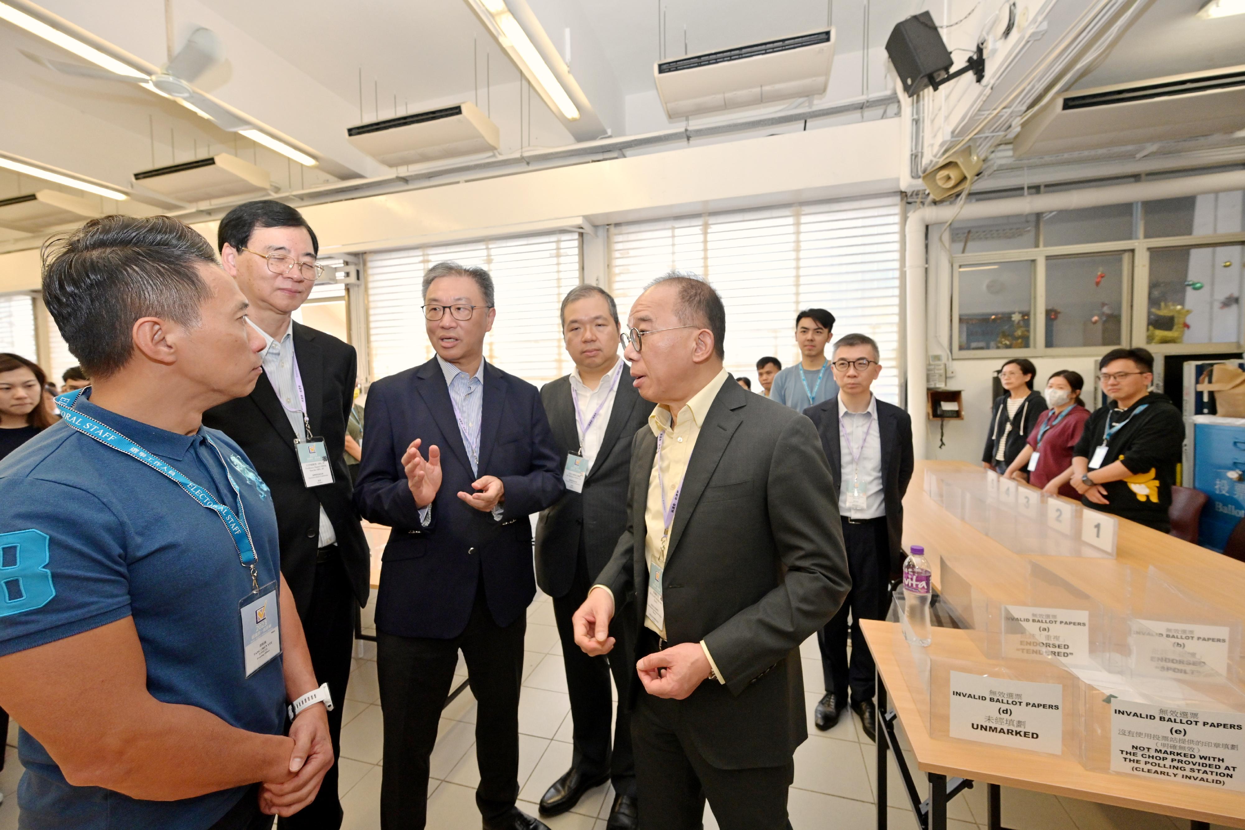 The Chairman of the Electoral Affairs Commission (EAC), Mr Justice David Lok (third left), the Secretary for Constitutional and Mainland Affairs, Mr Erick Tsang Kwok-wai (fifth left); the EAC members Professor Daniel Shek (second left) and Mr Bernard Man, SC (fourth left), visit a near boundary polling station of the 2023 District Council Ordinary Election this afternoon (December 9) to inspect the preparatory work.