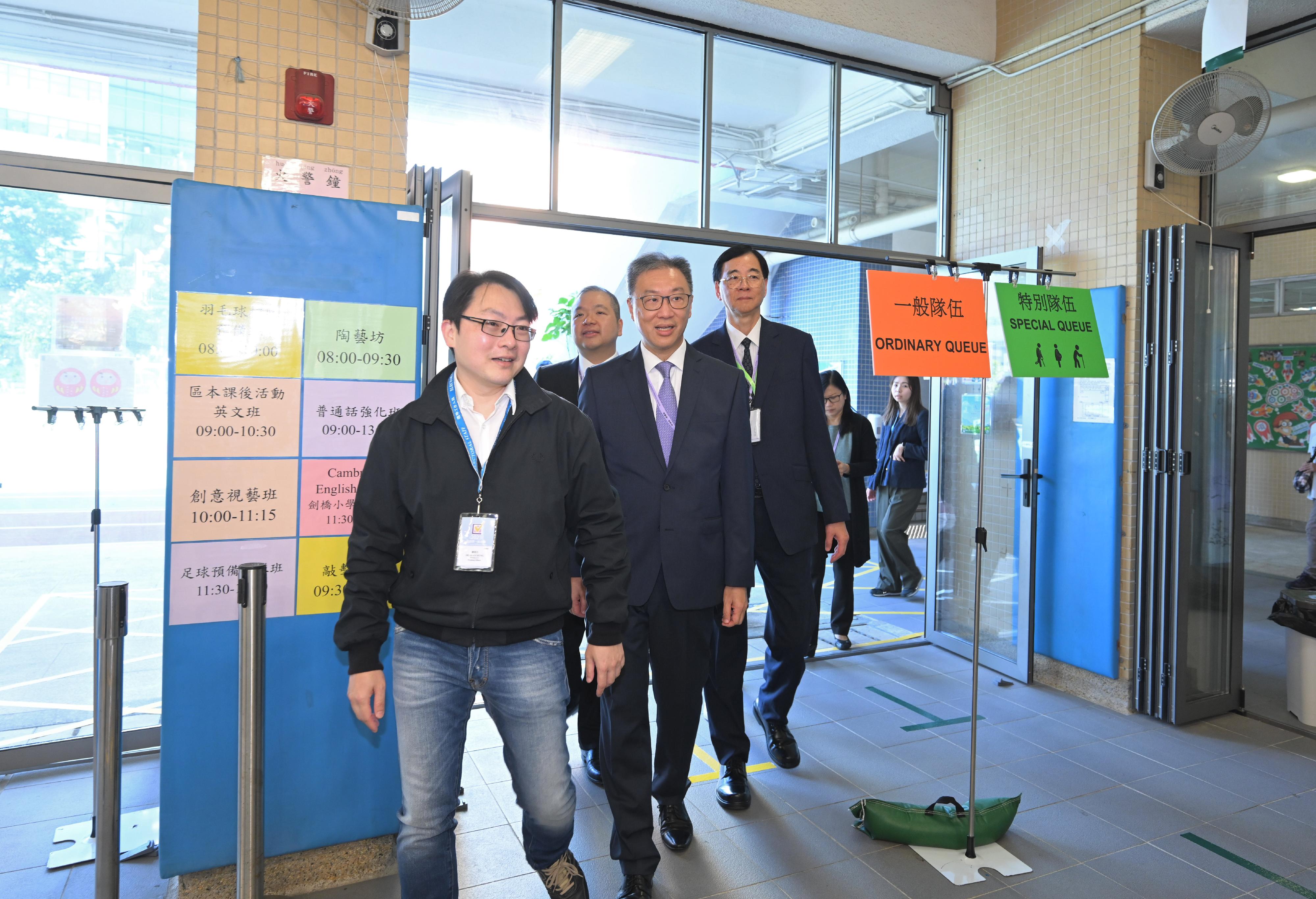 選舉管理委員會主席陸啟康法官（左三）、委員石丹理教授（左四）及文本立資深大律師（左二），今日（十二月十日）上午巡視設於油蔴地天主教小學（海泓道）的二○二三年區議會一般選舉區議會地方選區投票站，實地視察投票站的運作情況。