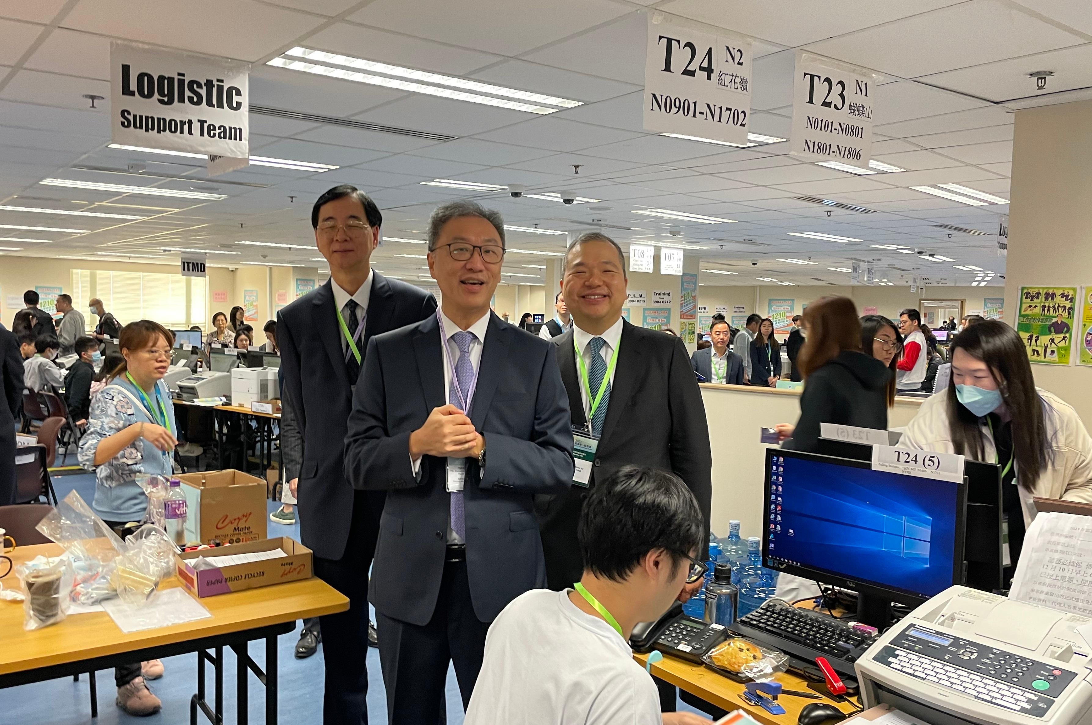 The Chairman of the Electoral Affairs Commission (EAC), Mr Justice David Lok (centre), visits the Central Command Centre and Statistical Information Centre of the 2023 District Council Ordinary Election at the Kowloonbay International Trade and Exhibition Centre this morning (December 10) and gives support to the electoral staff. Also present are EAC members Professor Daniel Shek (left) and Mr Bernard Man, SC (right).