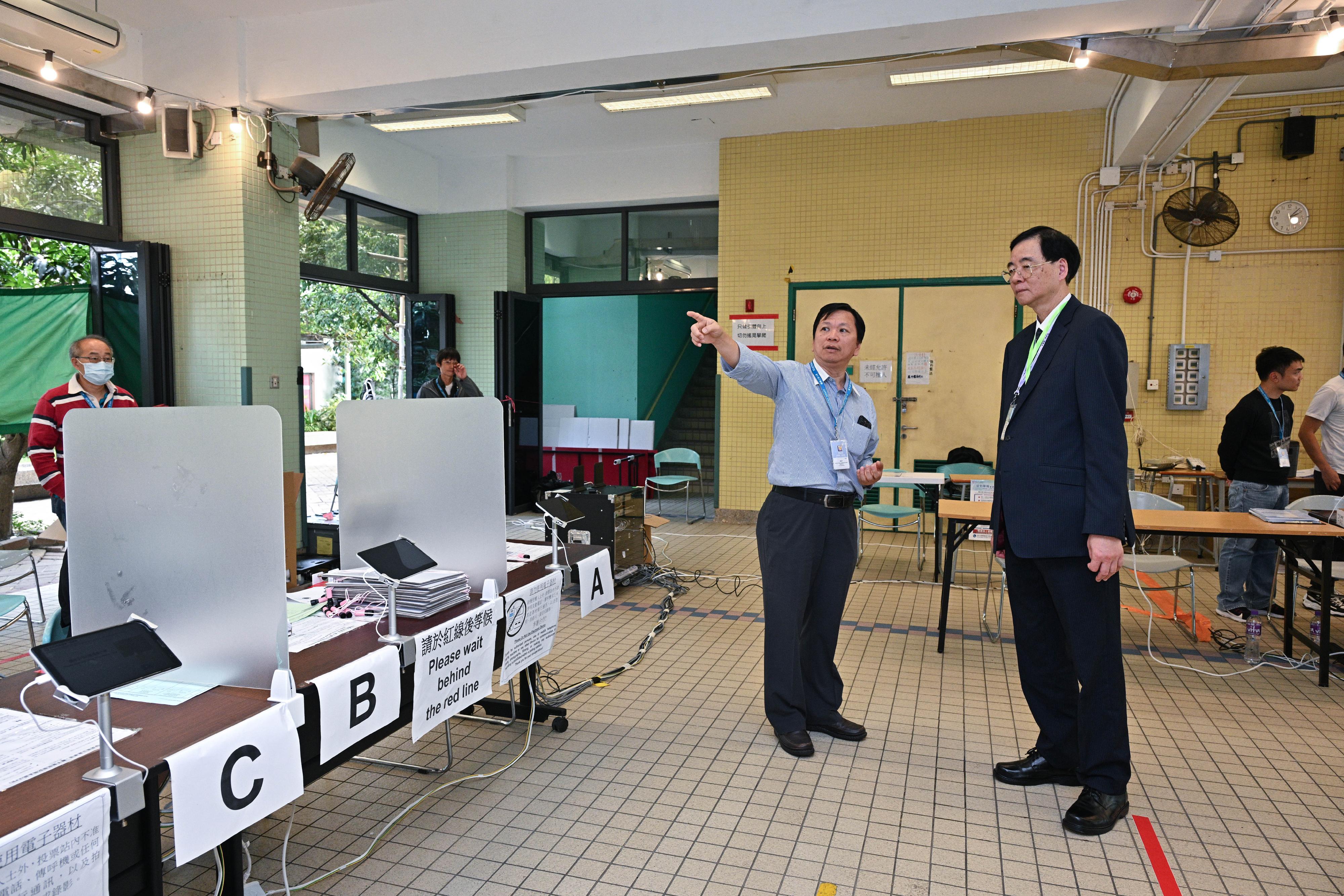The Electoral Affairs Commission member Professor Daniel Shek (front row, right) visits the District Council geographical constituency polling station of the 2023 District Council Ordinary Election at Yan Chai Hospital Law Chan Chor Si College this afternoon (December 10) to inspect the operation of the polling station. He is being briefed by the Presiding Officer.
