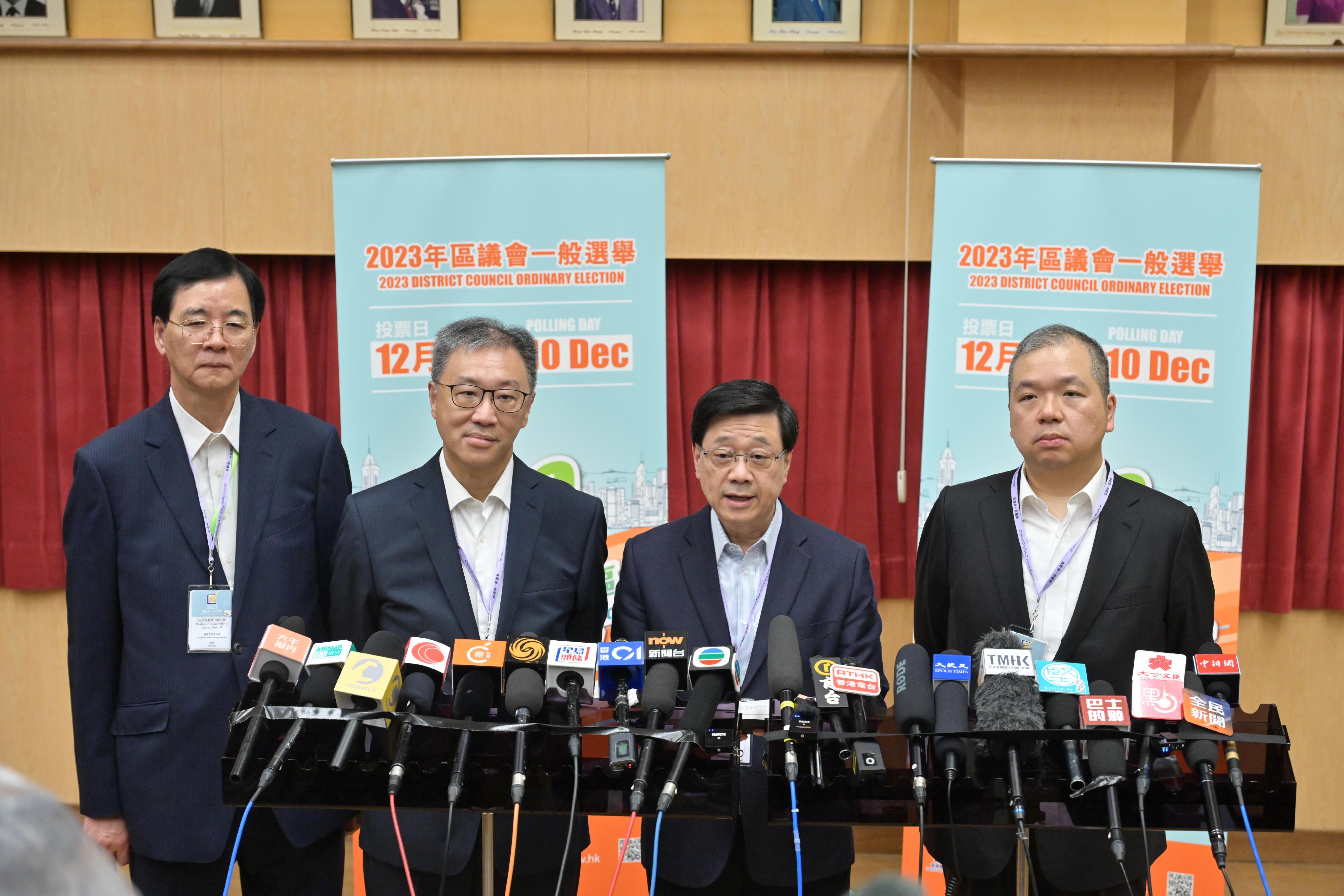 The Chief Executive, Mr John Lee (second right), together with the Chairman of the Electoral Affairs Commission (EAC), Mr Justice David Lok (second left); the EAC members Professor Daniel Shek (first left) and Mr Bernard Man, SC (first right), meet the media after visiting the polling station of 2023 District Council Ordinary Election at Queen's College early this morning (December 11).  