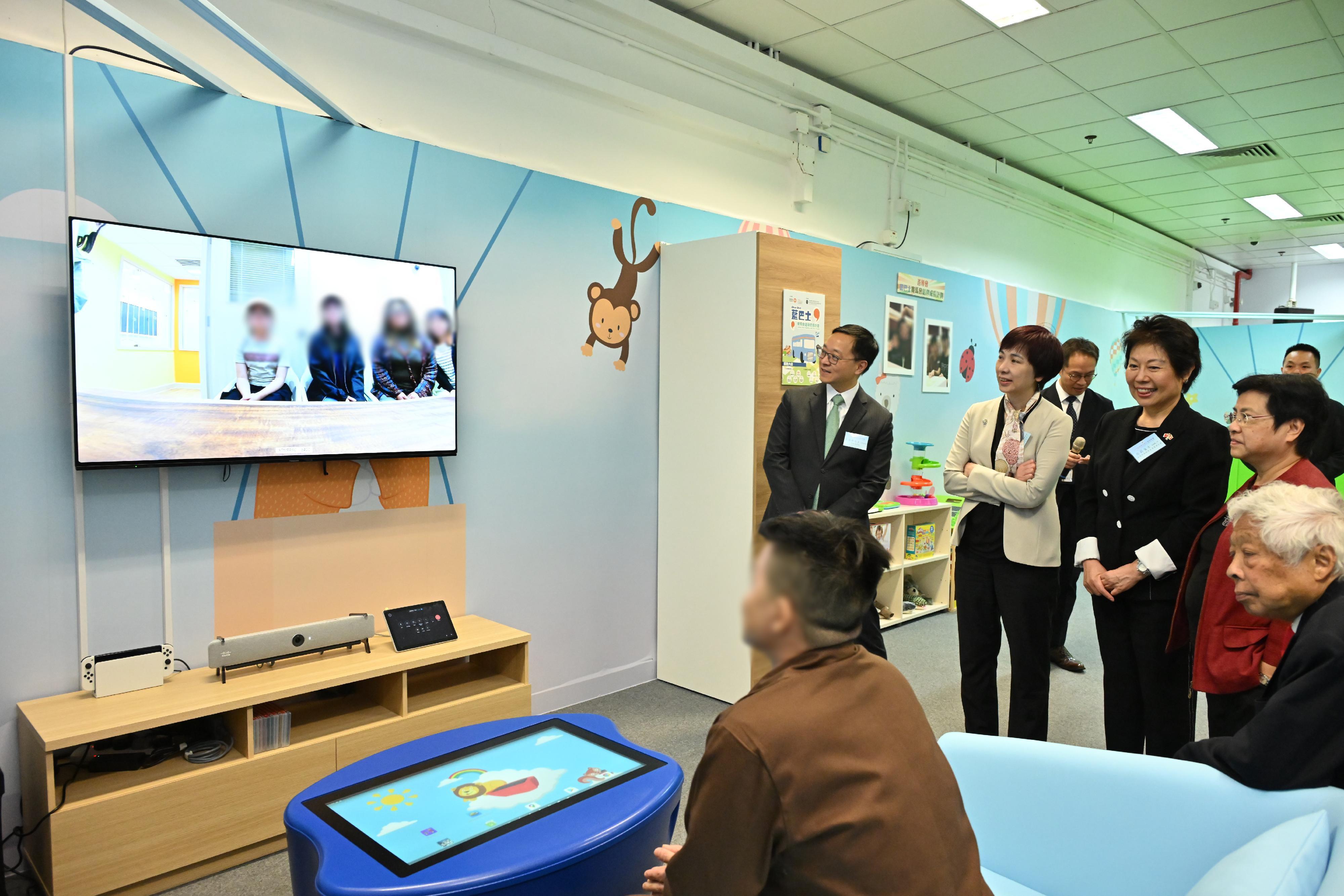 The Correctional Services Department officially launched a Parent-child Centre in Stanley Prison today (December 13). Photo shows the Chairman of the Committee on Community Support for Rehabilitated Offenders, Ms Tsui Li (first row, third left); the Head of Charities (Youth Development & Poverty Alleviation) of the Hong Kong Jockey Club, Ms Winnie Ying (first row, second left); and the Commissioner of Correctional Services, Mr Wong Kwok-hing (first row, first left); and other guests learning about the video social visit service for persons in custody and their families in the centre.