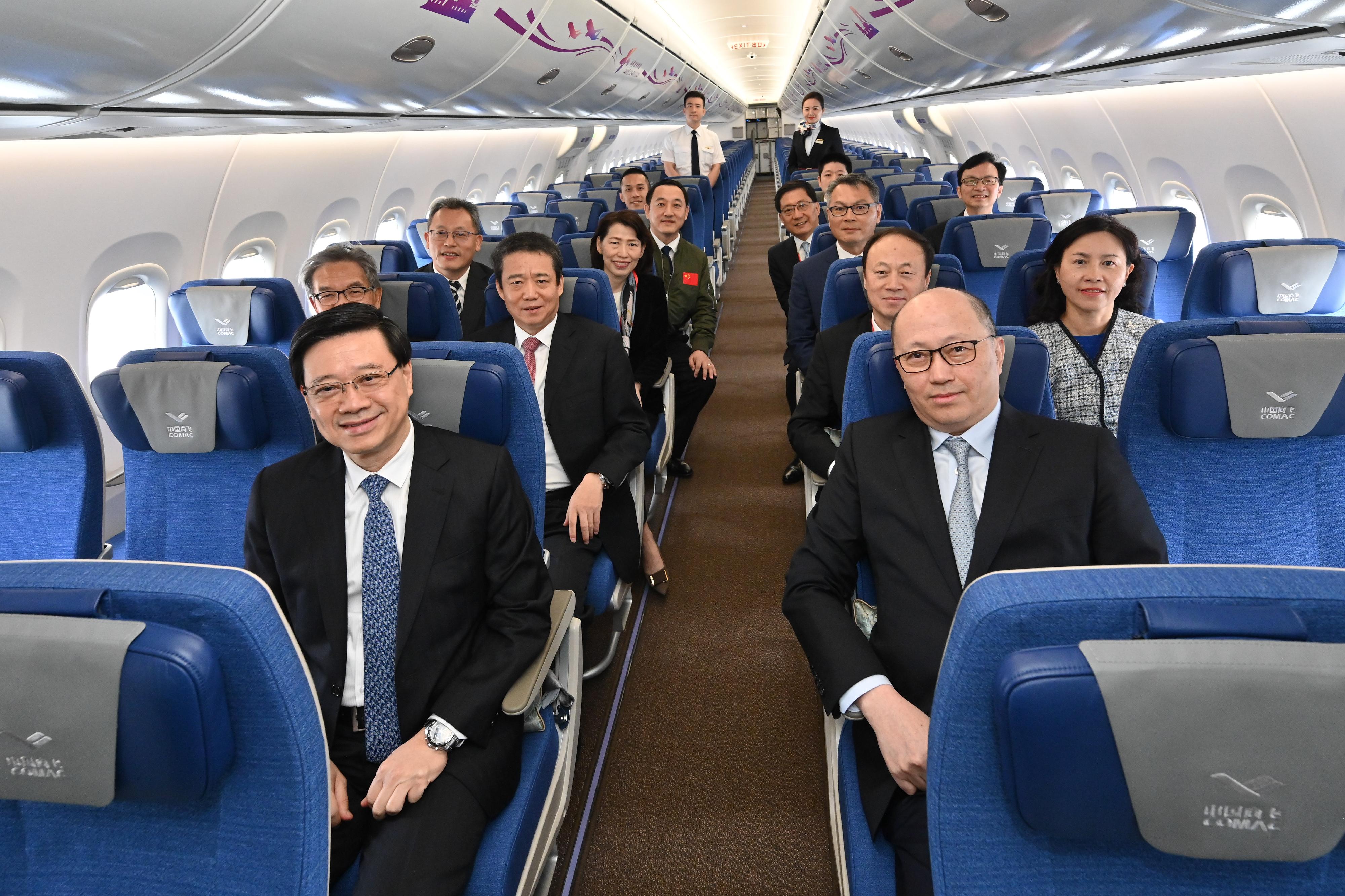 The Chief Executive, Mr John Lee, attended the welcome ceremony for aircraft C919 and ARJ21 today (December 13). Photo shows Mr Lee (first row, left), the Director of the Liaison Office of the Central People's Government in the Hong Kong Special Administrative Region, Mr Zheng Yanxiong (first row, right), and other guests in the economy class cabin of aircraft C919.  

