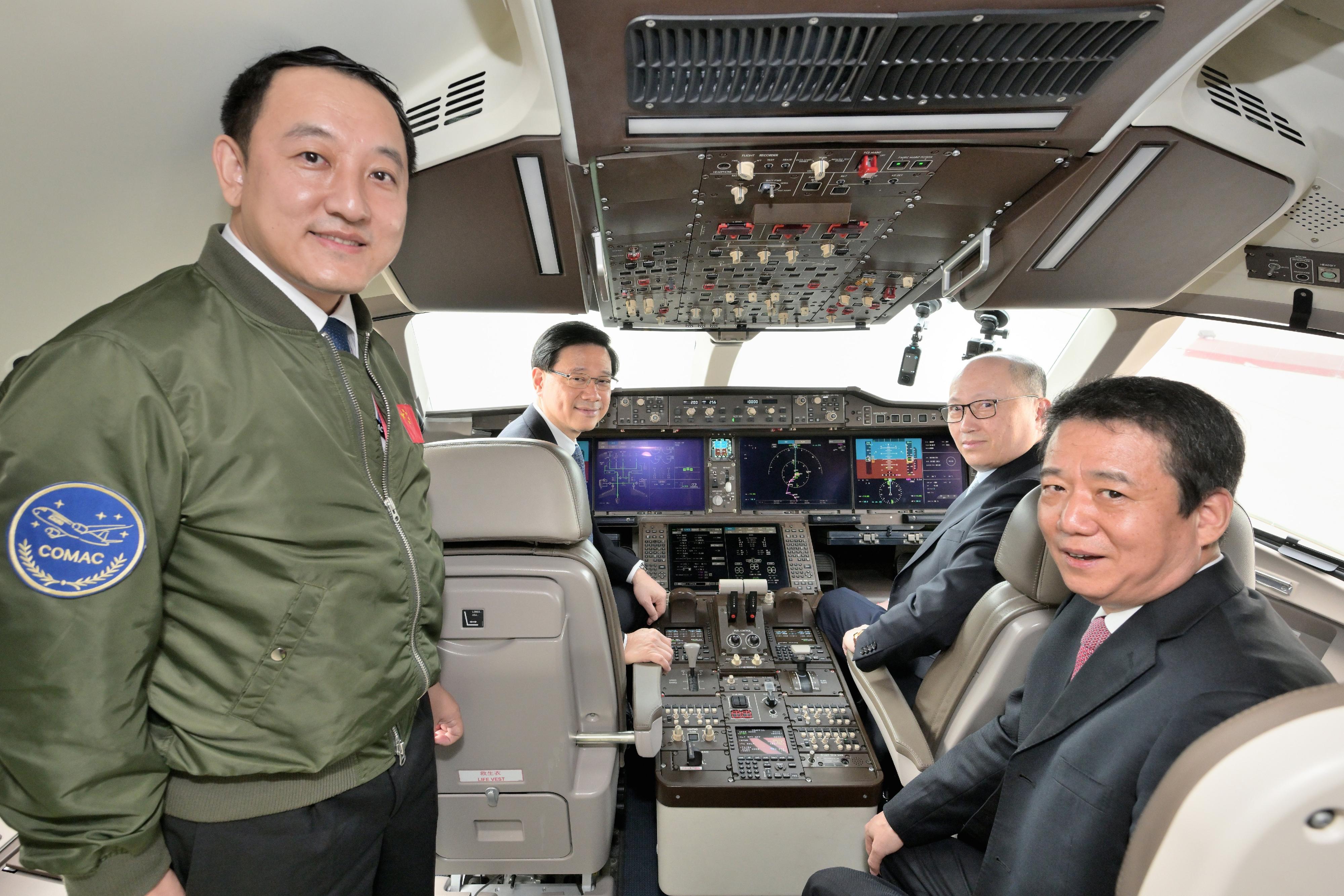 The Chief Executive, Mr John Lee, attended the welcome ceremony for aircraft C919 and ARJ21 today (December 13). Photo shows Mr Lee (back row, left) and the Director of the Liaison Office of the Central People's Government in the Hong Kong Special Administrative Region, Mr Zheng Yanxiong (back row, right), accompanied by Deputy Administrator of the Civil Aviation Administration of China Mr Cui Xiaofeng (front row, right) and Chief Flight Operation Pilot of Commercial Aircraft Corporation of China, Ltd Captain Tong Yu (front row, left), in the cockpit of aircraft C919.  