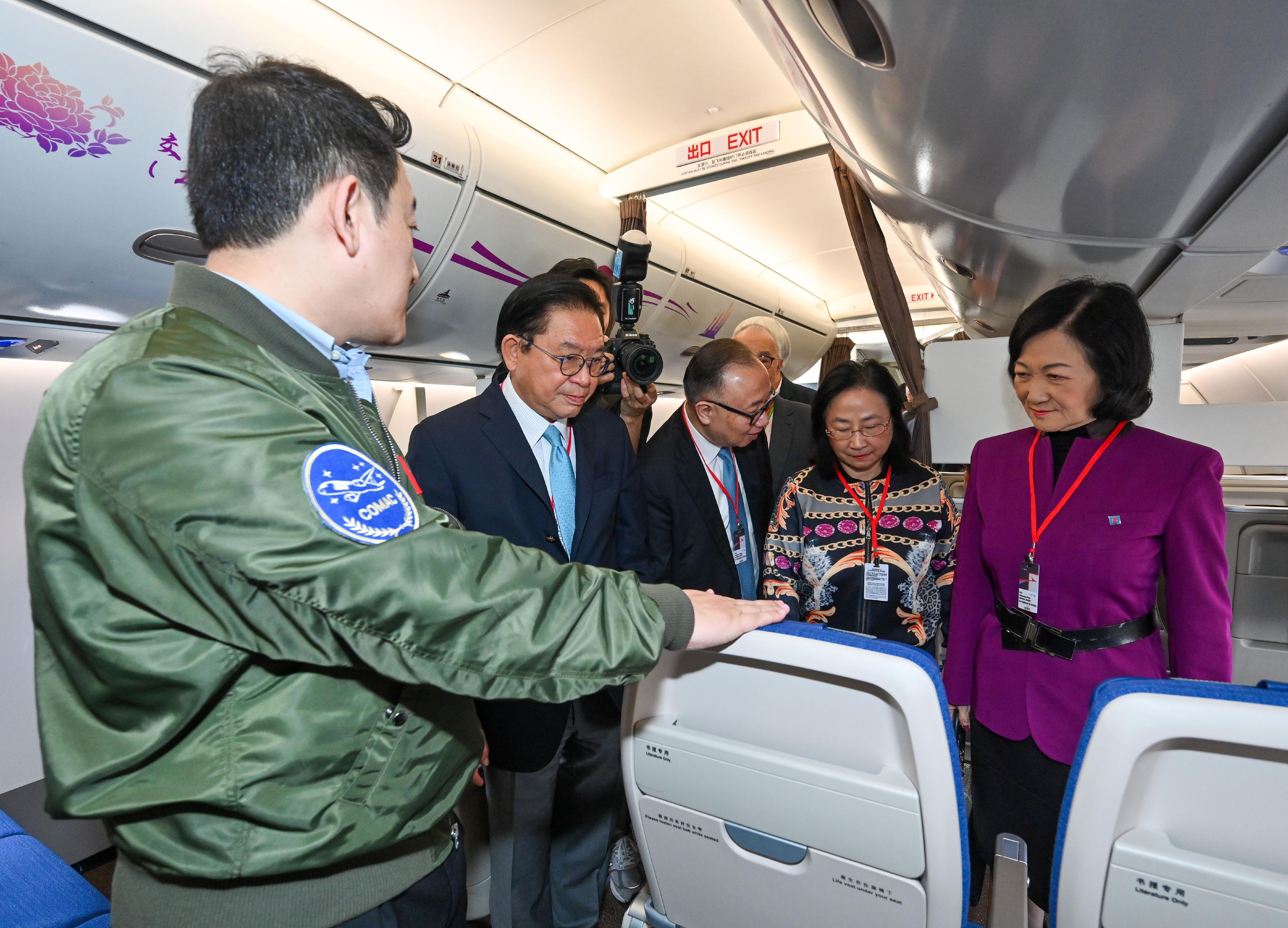 Non-official Members of the Executive Council (ExCo Non-official Members) today (December 14) visited the home-developed aircraft C919 and ARJ21. Photo shows the ExCo Non-official Members being briefed by the Chief Flight Operation Pilot of Commercial Aircraft Corporation of China, Ltd, Captain Tong Yu (left), in the cabin of aircraft C919.