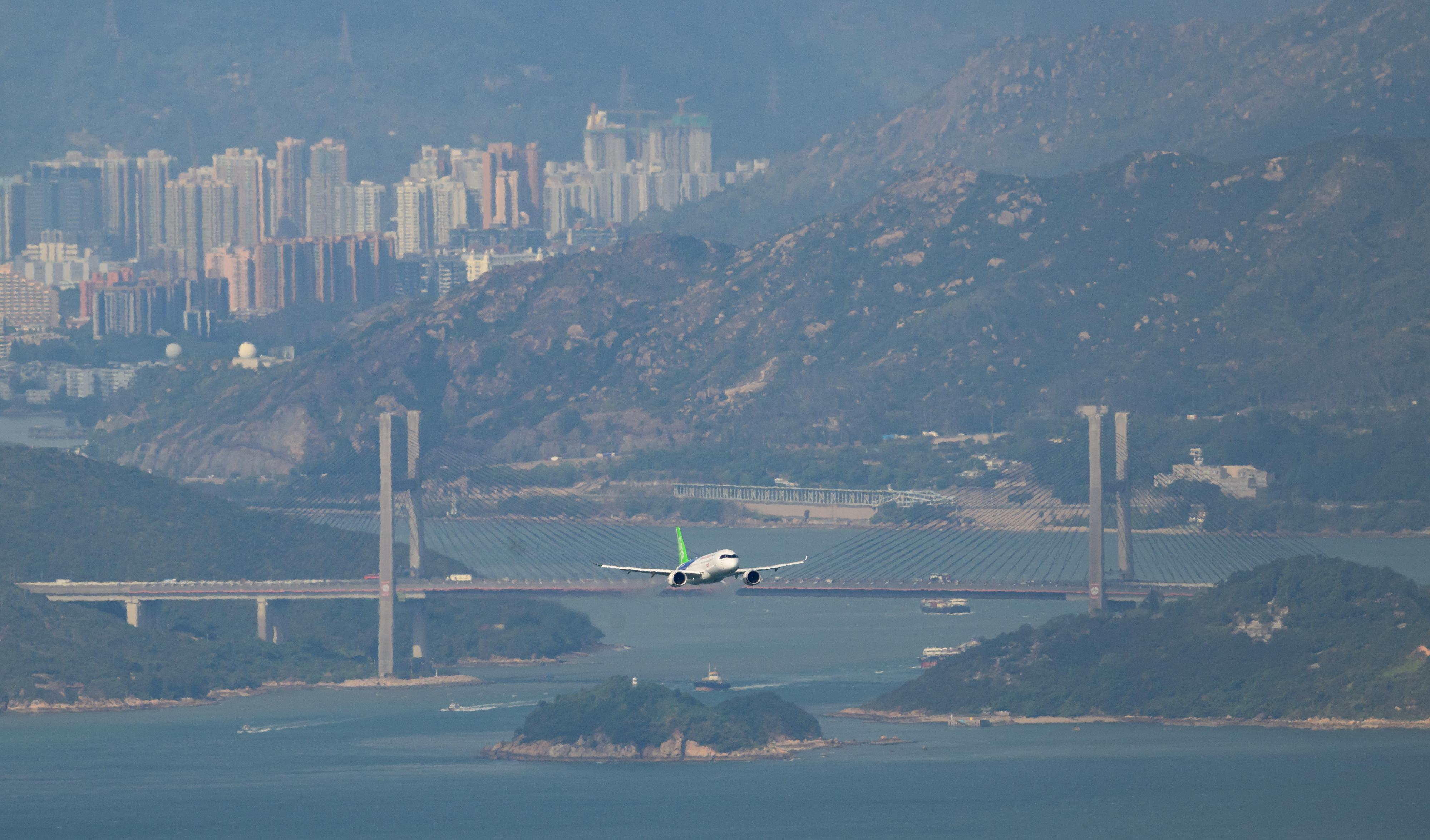 The flight demonstration of home-grown aircraft C919 concluded successfully this morning (December 16). Photo shows the C919 aircraft flying towards Victoria Harbour for flight demonstration from Hong Kong International Airport.