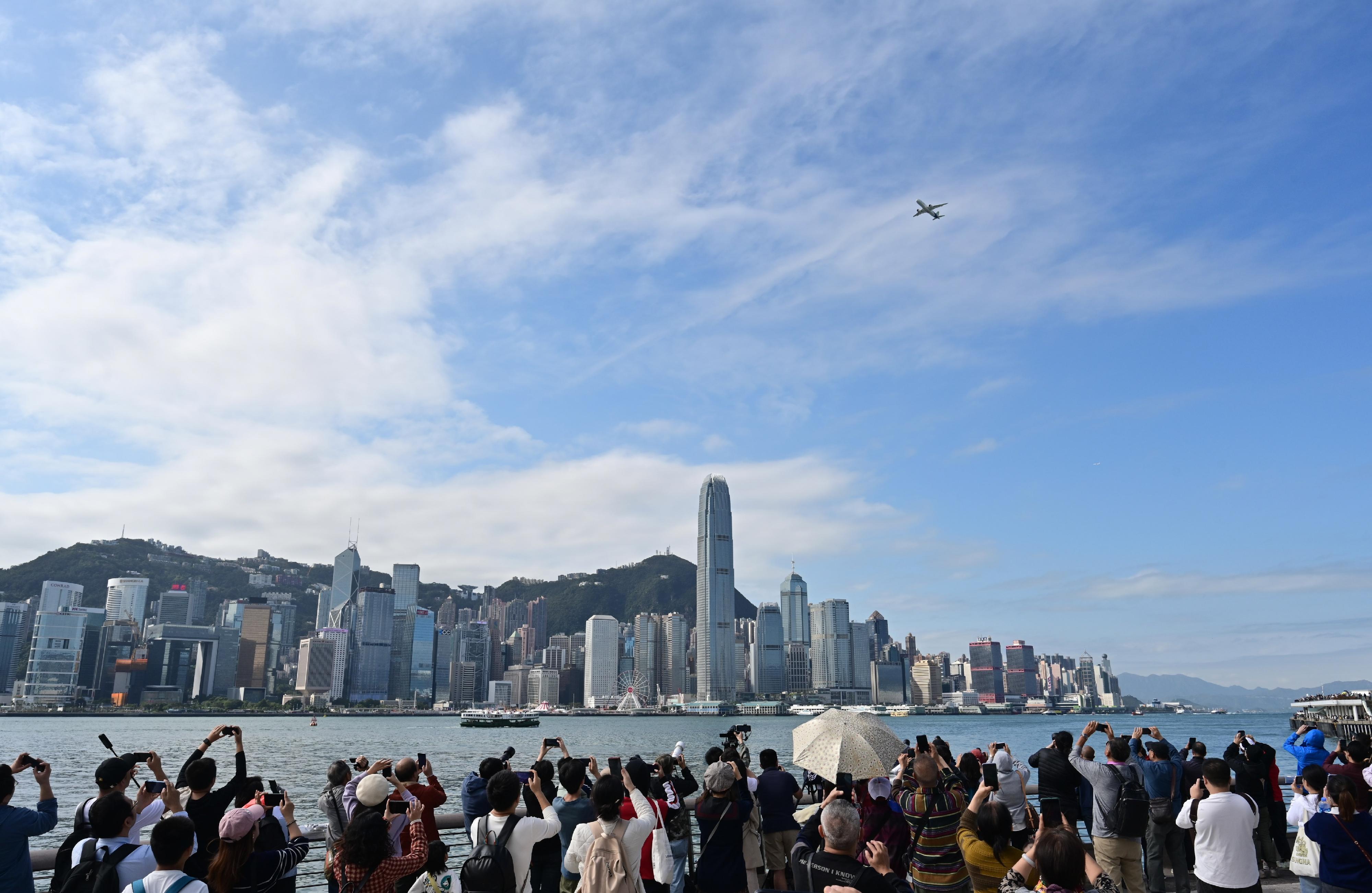 The flight demonstration of home-grown aircraft C919 concluded successfully this morning (December 16). Photo shows members of the public and tourists witnessing the historic moment of the domestic C919 aircraft making its debut appearance over Victoria Harbour.