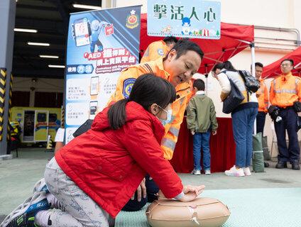 The Fire Services Department today (December 17) held the Fire Safety Activities during Festive Season Campaign 2023 cum Sha Tin Fire Station and Ambulance Depot Open Day. Photo shows ambulance personnel teaching a member of the public how to perform cardiopulmonary resuscitation.