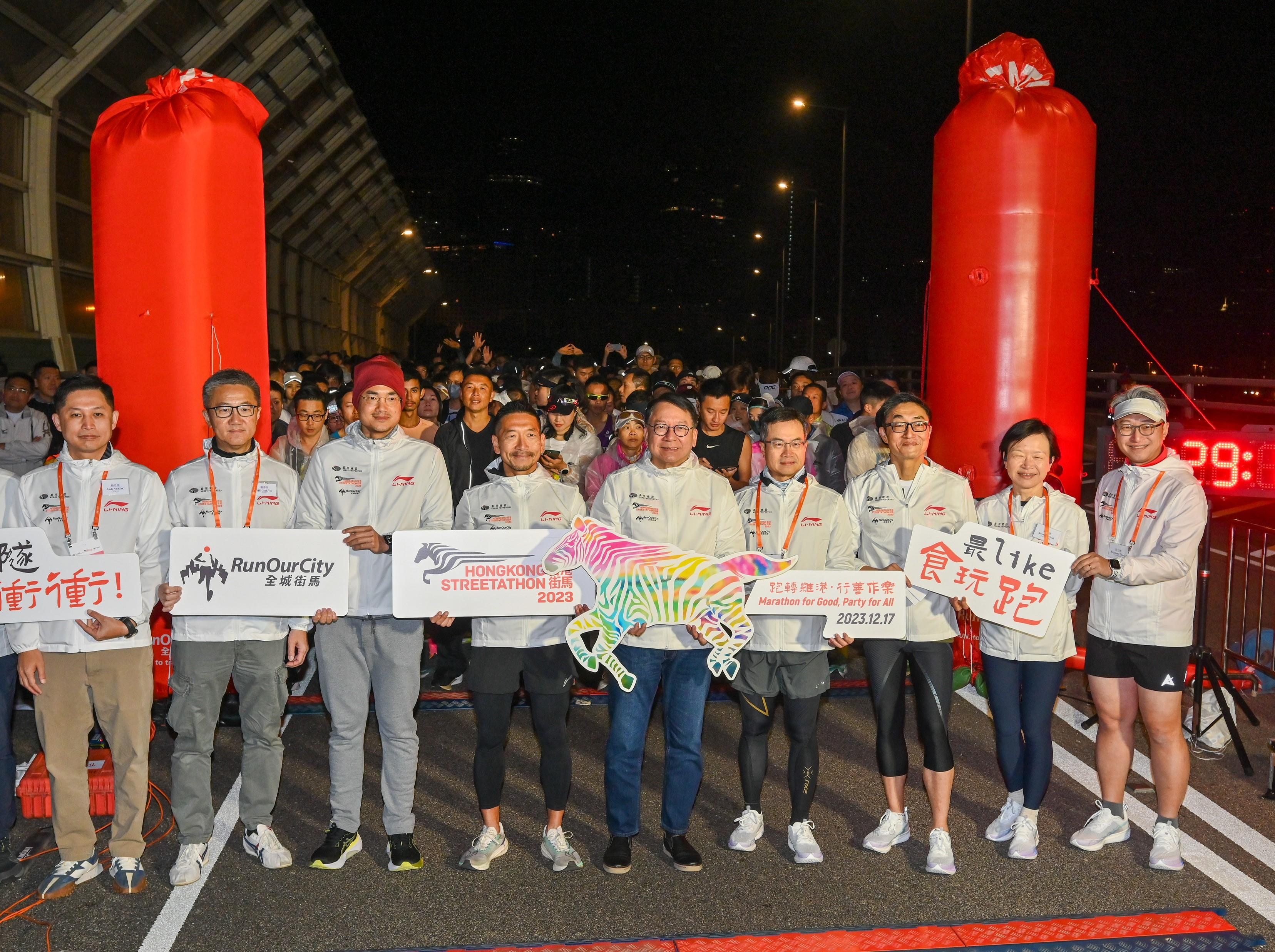 政务司司长陈国基今日（十二月十七日）出席「香港街马2023」慈善跑开跑典礼。图示陈国基（中）和一众嘉宾和跑手在起跑前合照。