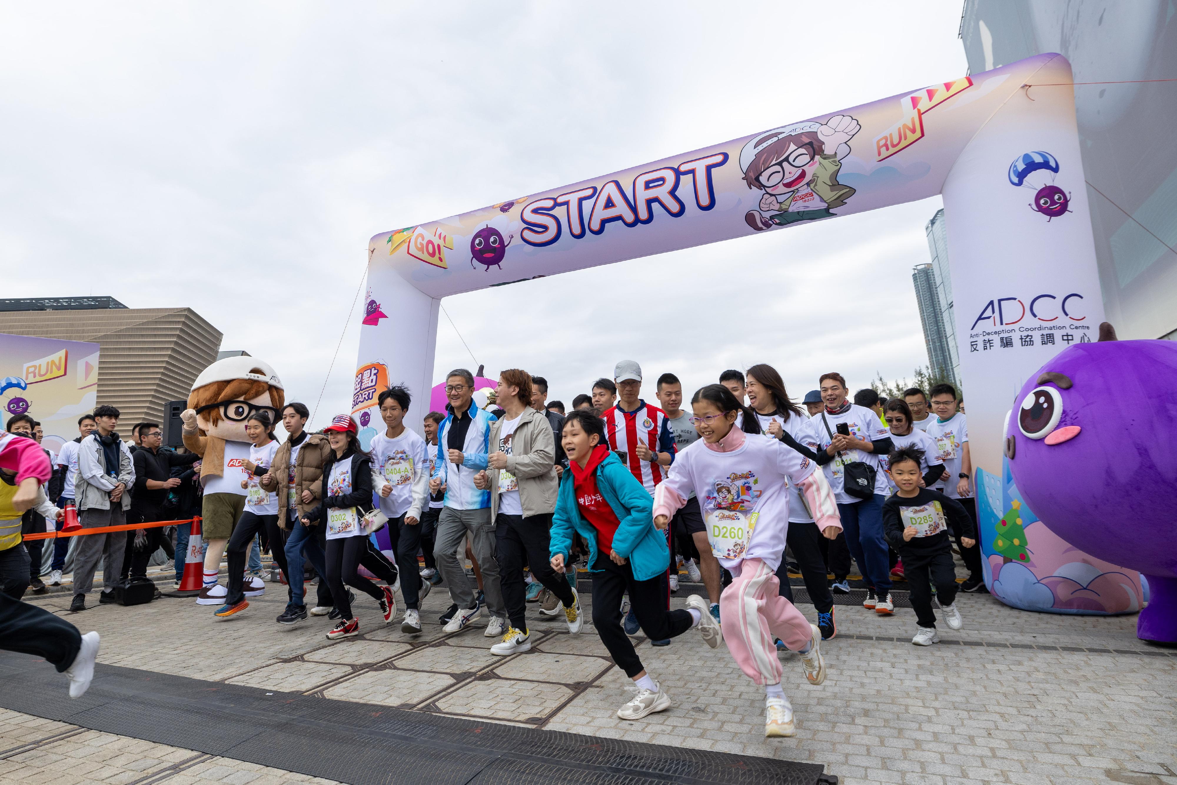 The Anti-Deception Coordination Centre of the Hong Kong Police Force organises the "West Kowloon CHILL RUN Winter Market cum Anti-Scam Charity Run 2023" at the West Kowloon Cultural District today (December 17). Photo shows the Commissioner of Police, Mr Siu Chak-yee (front row, centre) attending the event, promoting the public awareness of scam prevention with other runners.