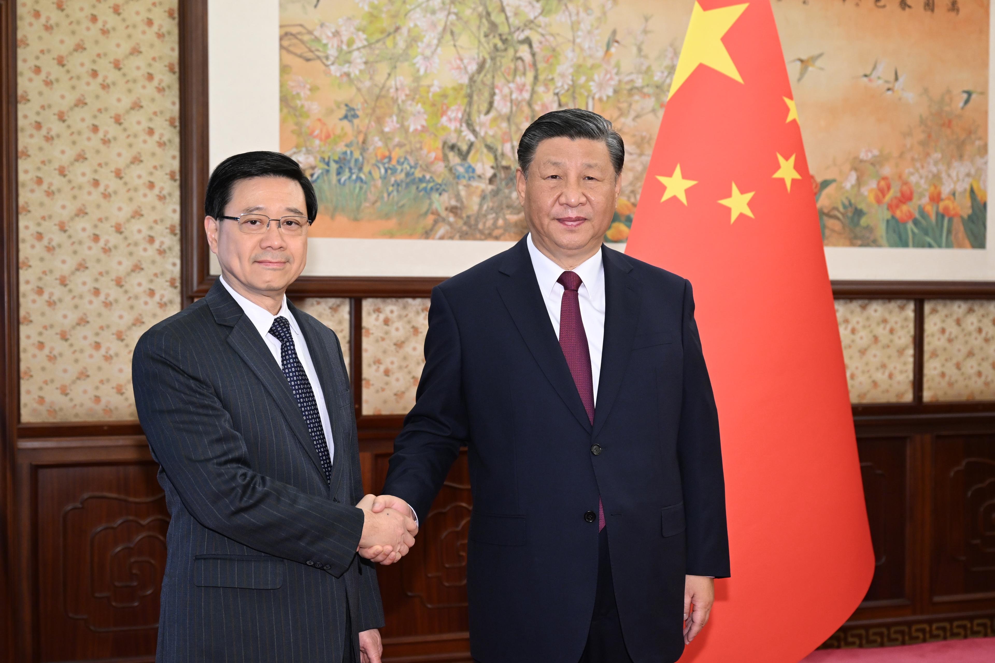 行政長官李家超（左）今日（十二月十八日）在北京向國家主席習近平（右）述職，匯報香港經濟、社會和政治等方面的最新情況。圖示二人在會面前合照。