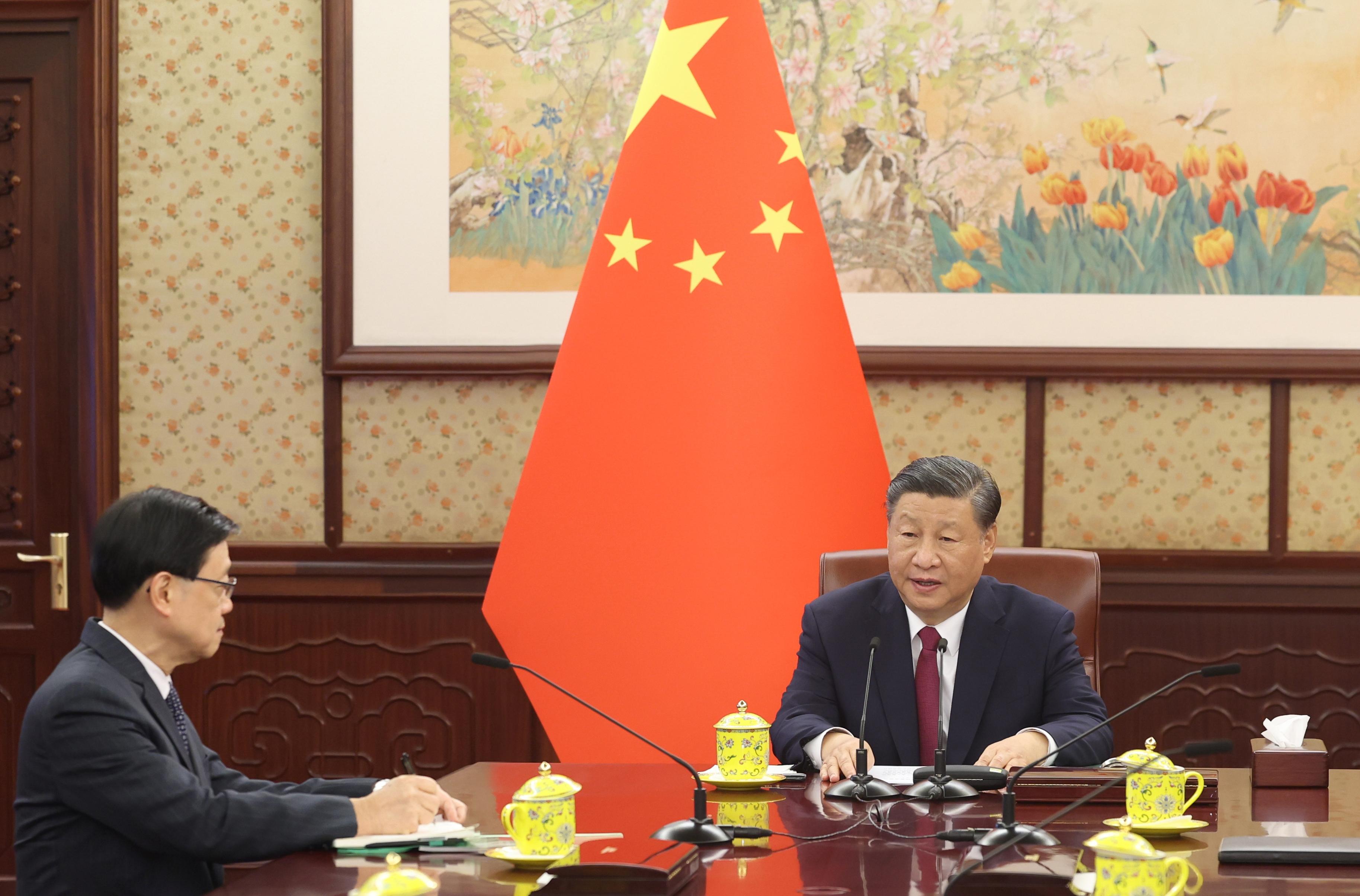 The Chief Executive, Mr John Lee (left), briefs President Xi Jinping (right) in Beijing today (December 18) on the latest economic, social and political situation in Hong Kong.