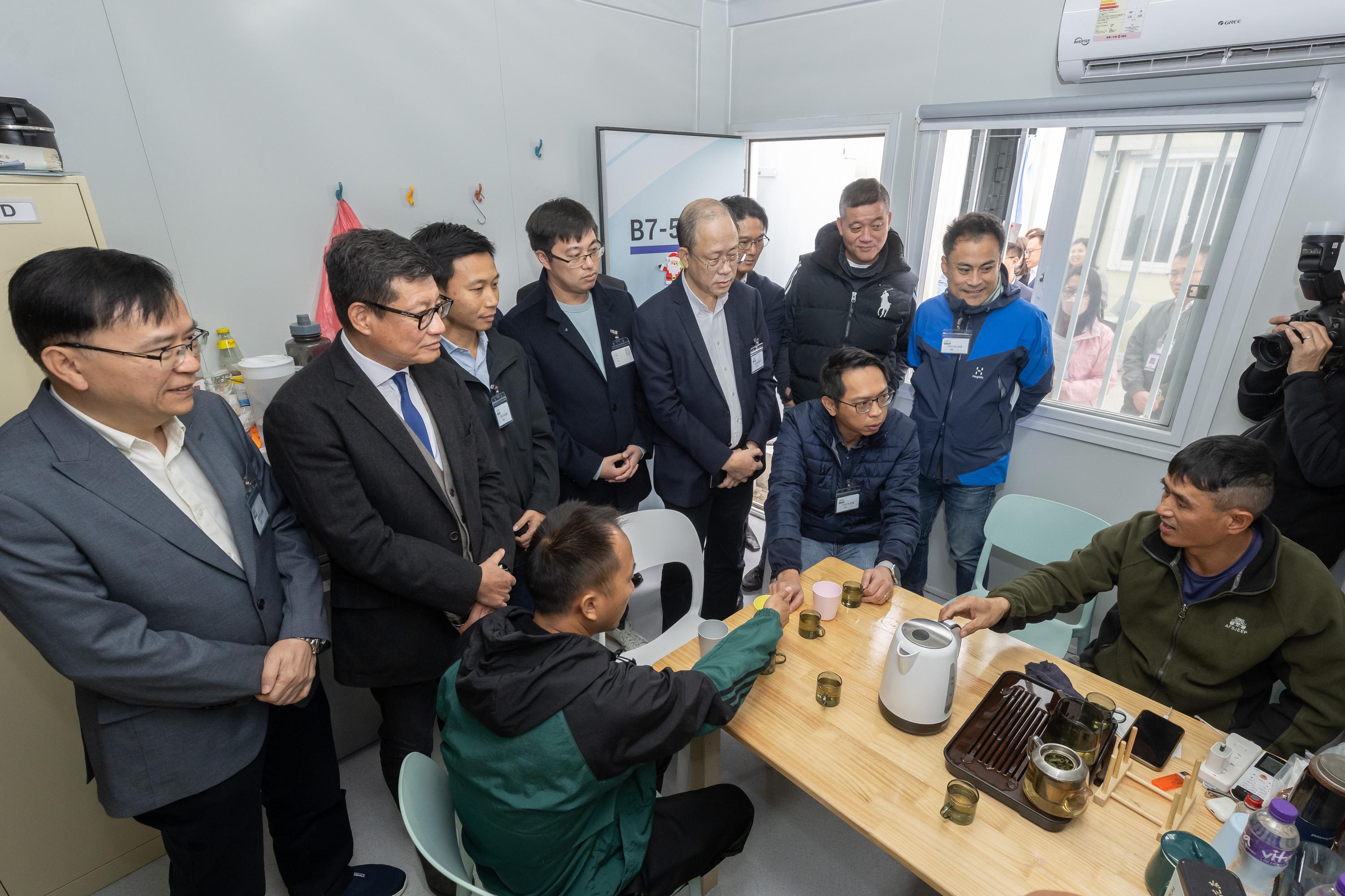 The Legislative Council Panel on Manpower visited the Construction Sector Imported Labour Quarters in Tam Mi, Yuen Long, today (December 19). Photo shows Members exchanging views with imported labourers to learn about their daily lives in Hong Kong and the support they required.