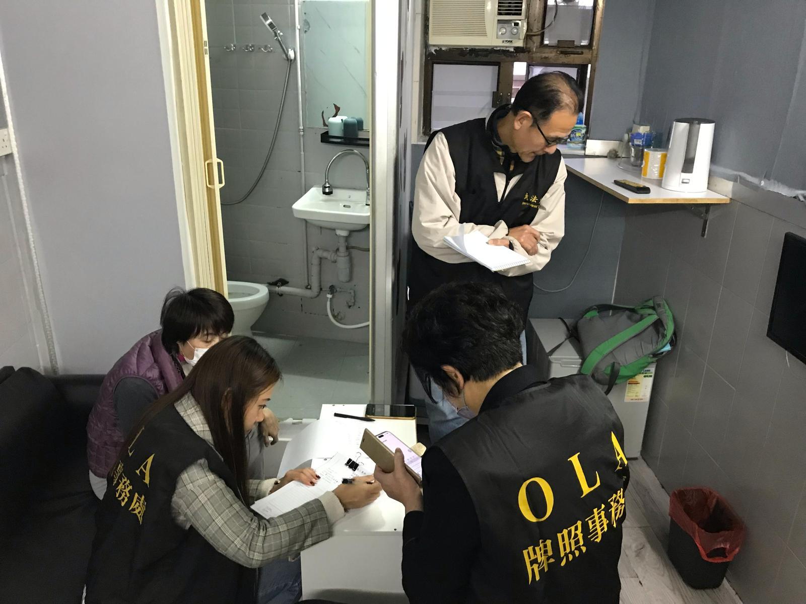 The Office of the Licensing Authority (OLA) of the Home Affairs Department conducted a joint operation with the Fire Services Department codenamed "Solar Flare" against unlicensed hotels/guesthouses and illegal club-house operations for two consecutive days on December 20 and 21 at various spots in areas of Hong Kong Island and Kowloon. Photo shows OLA enforcement officers searching for evidence in a suspected unlicensed guesthouse.