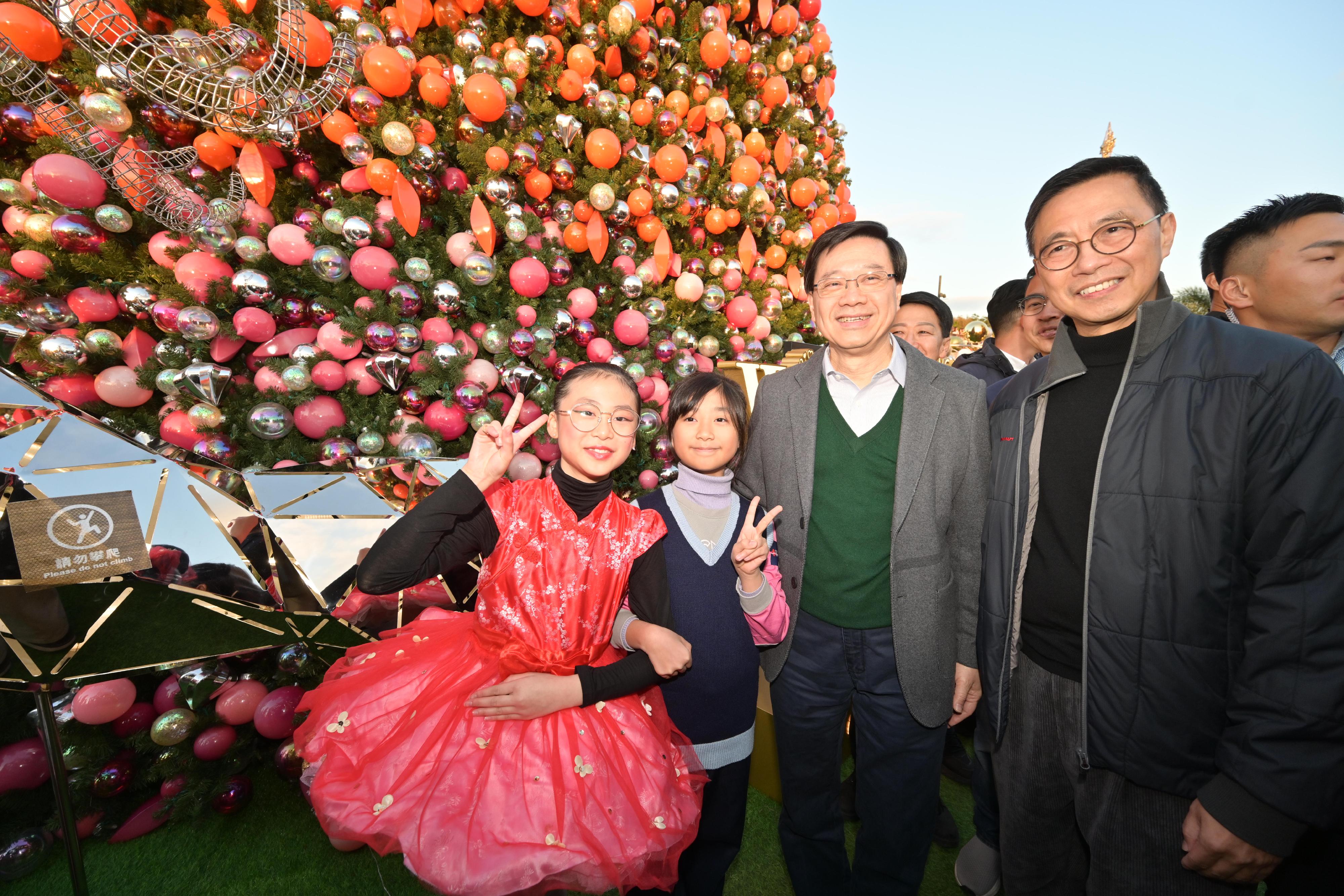 行政長官李家超今日（十二月二十三日）參觀位於西九文化區的2023香港繽紛冬日巡禮──聖誕小鎮。圖示李家超（右二）和文化體育及旅遊局局長楊潤雄（右一）與小朋友合照。