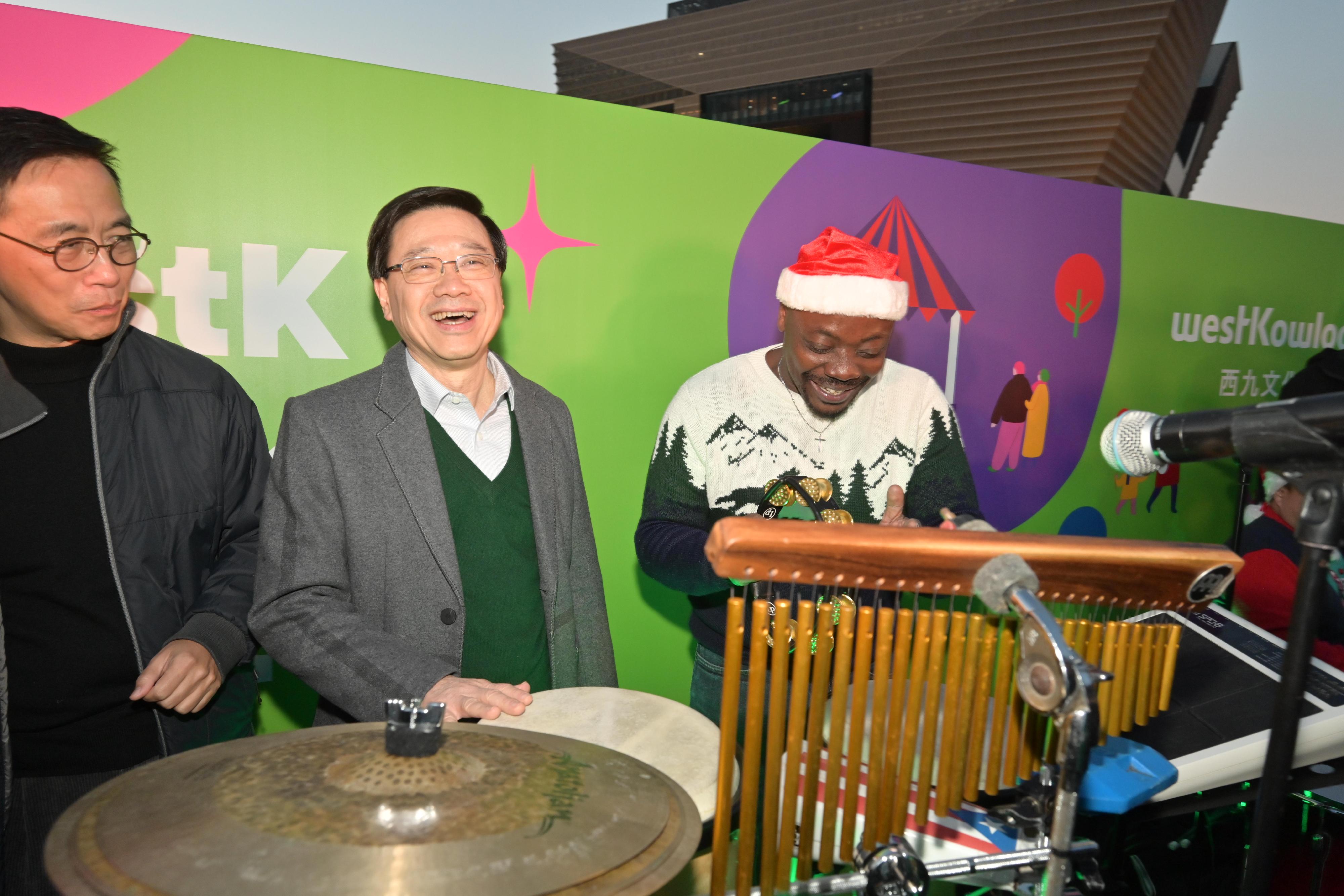 行政长官李家超今日（十二月二十三日）参观位于西九文化区的2023香港缤纷冬日巡礼──圣诞小镇。图示李家超（中）参与音乐表演。旁为文化体育及旅游局局长杨润雄（左）。