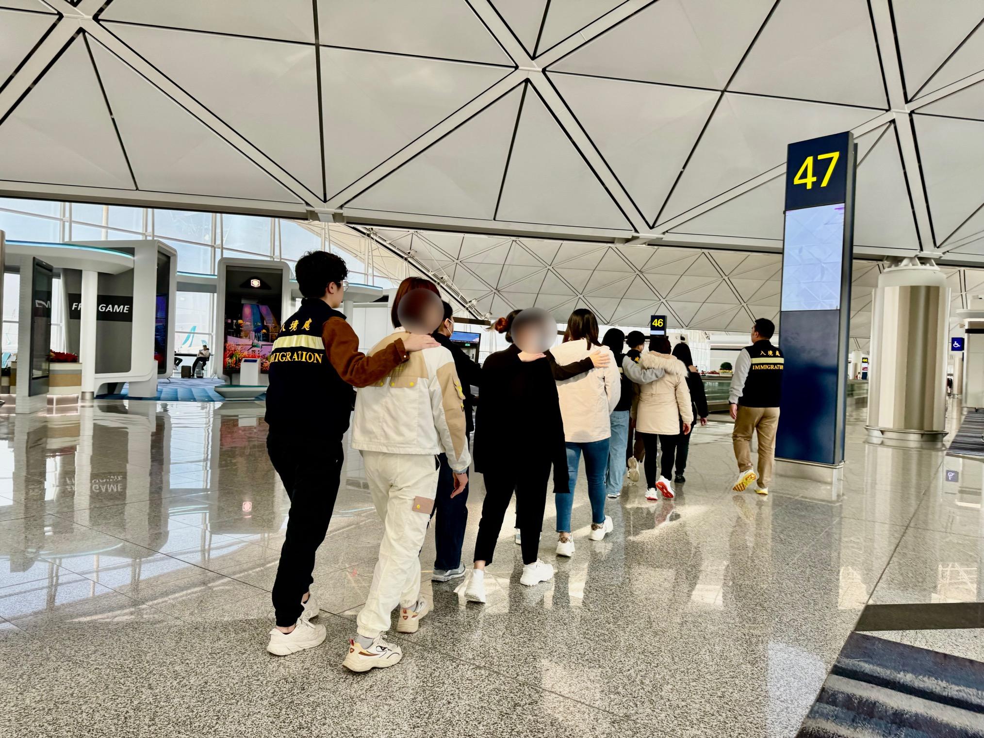 入境事务处（入境处）今日（十二月二十八日）执行遣送行动，将16名越南籍非法入境者遣返越南。图示被遣返人士在入境处人员押送下离港。