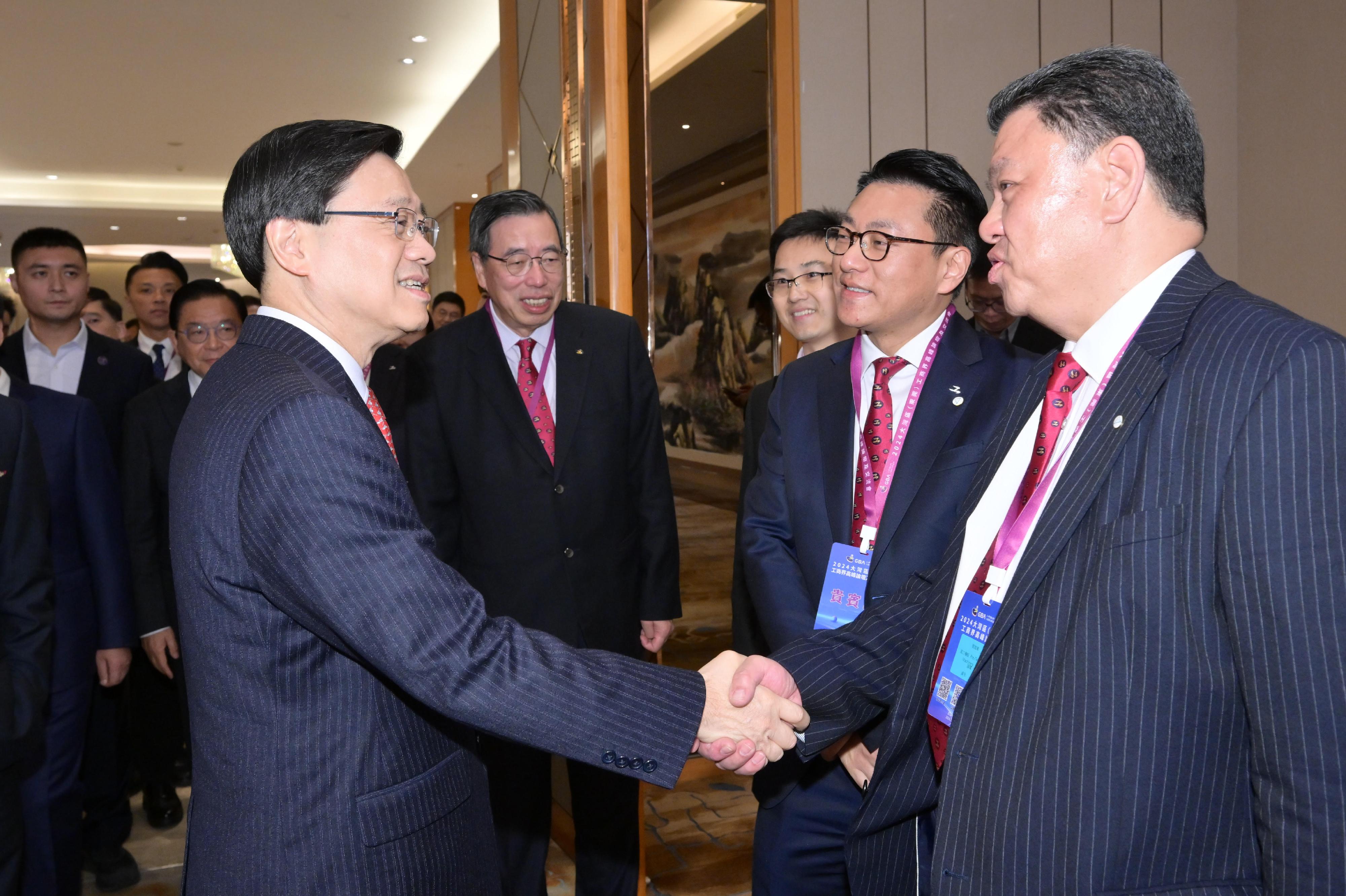 行政长官李家超今日（一月四日）在东莞出席由香港工业总会举办的2024大湾区（东莞）工商界高峰论坛。图示李家超（左一）和其他嘉宾交流。