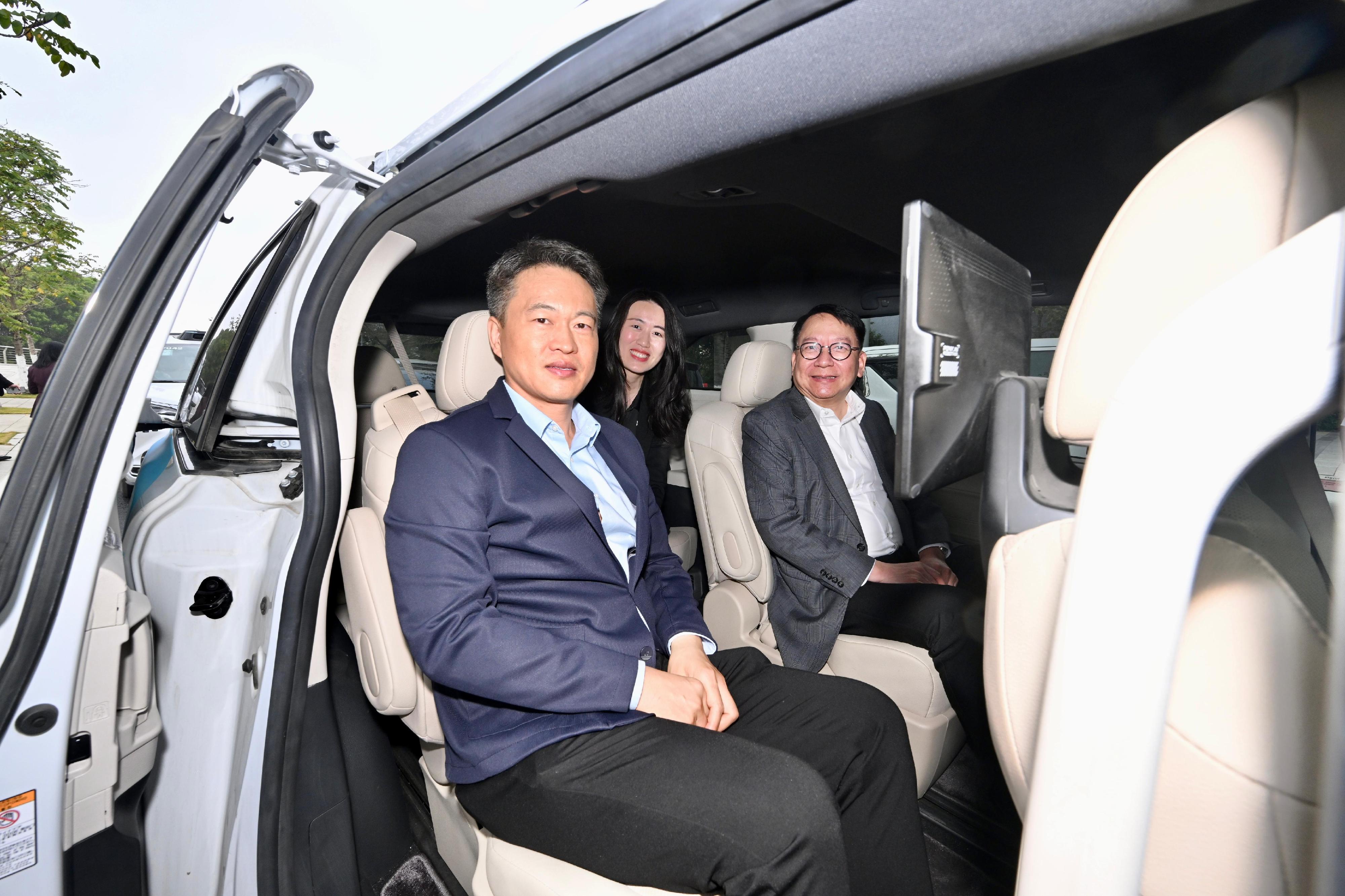 The Chief Secretary for Administration, Mr Chan Kwok-ki, continued his visit to Mainland cities of the Guangdong-Hong Kong-Macao Greater Bay Area in Guangzhou and Huizhou today (January 9). Photo shows Mr Chan (right) accompanied by Vice President of Pony.ai Ms Mo Luyi (centre) taking a Robotaxi of the company in Nansha, Guangzhou.