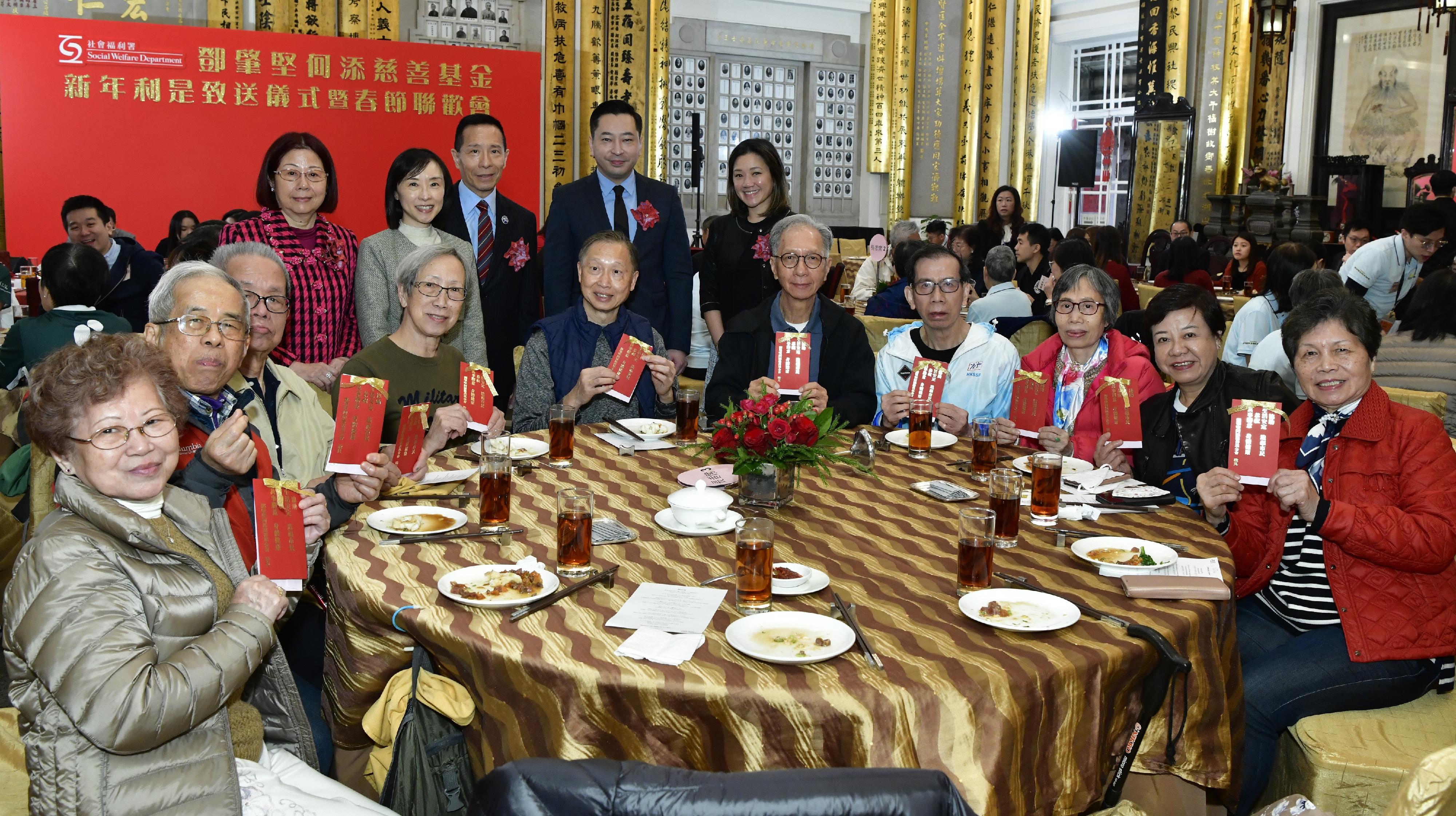 The Social Welfare Department and the Management Committee of the Tang Shiu Kin and Ho Tim Charitable Fund (the Fund) today (January 16) hosted a spring reception for the elderly and presented lai see packets to them in celebration of the upcoming Lunar New Year. Photo shows the Director of Social Welfare, Miss Charmaine Lee (back row, second left), together with descendants of the Fund's founders, Mr Richard Tang (back row, third left) and Miss Veronica Ho (back row, first right); the Chairman of the Tung Wah Group of Hospitals, Mr Herman Wai (back row, second right); and the Chairman of Po Leung Kuk, Mrs Winnie Chan (back row, first left), greeting elderly participants with lai see packets in celebration of the coming Lunar New Year.